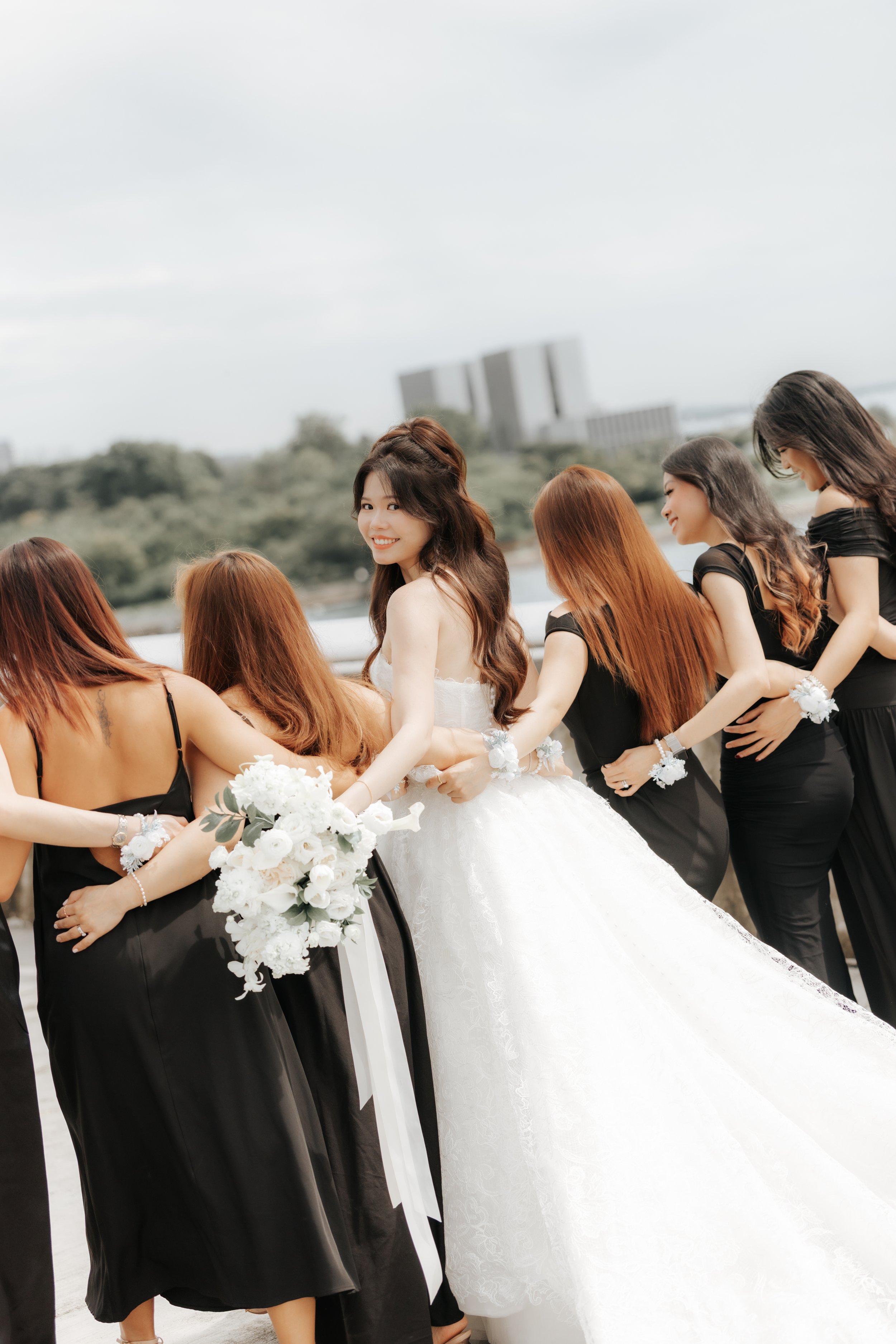 Charming actual day wedding photo of the bride and her bridesmaids, this was captured along Marina Barrage by Breadandbutterworks in a soft and heartfelt style.