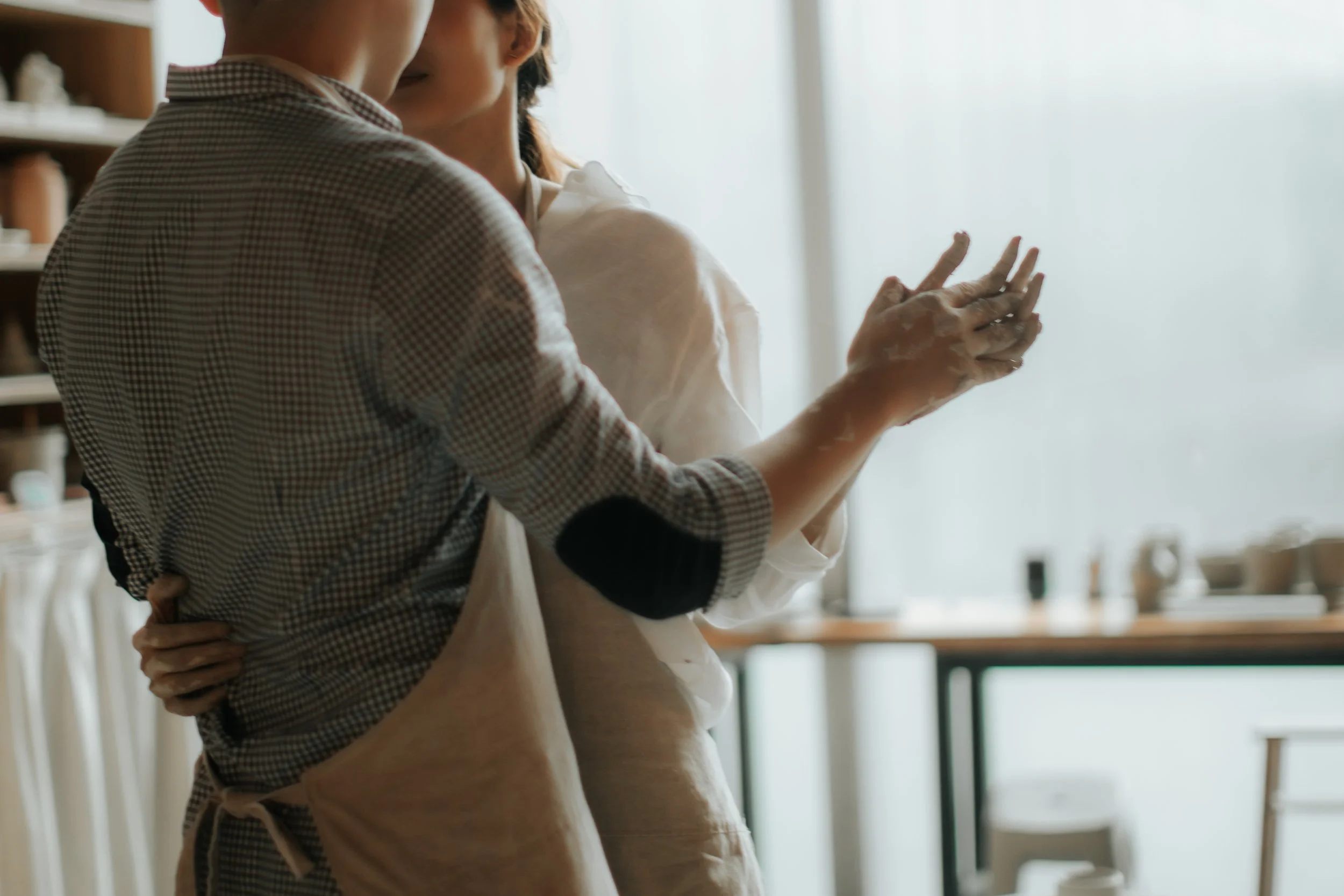 Intimate pre-wedding photoshoot at a pottery studio in Singapore (Tao Pottery), the couple share an intimate slow dance. Captured in the light and airy style of Breadandbutterworks.