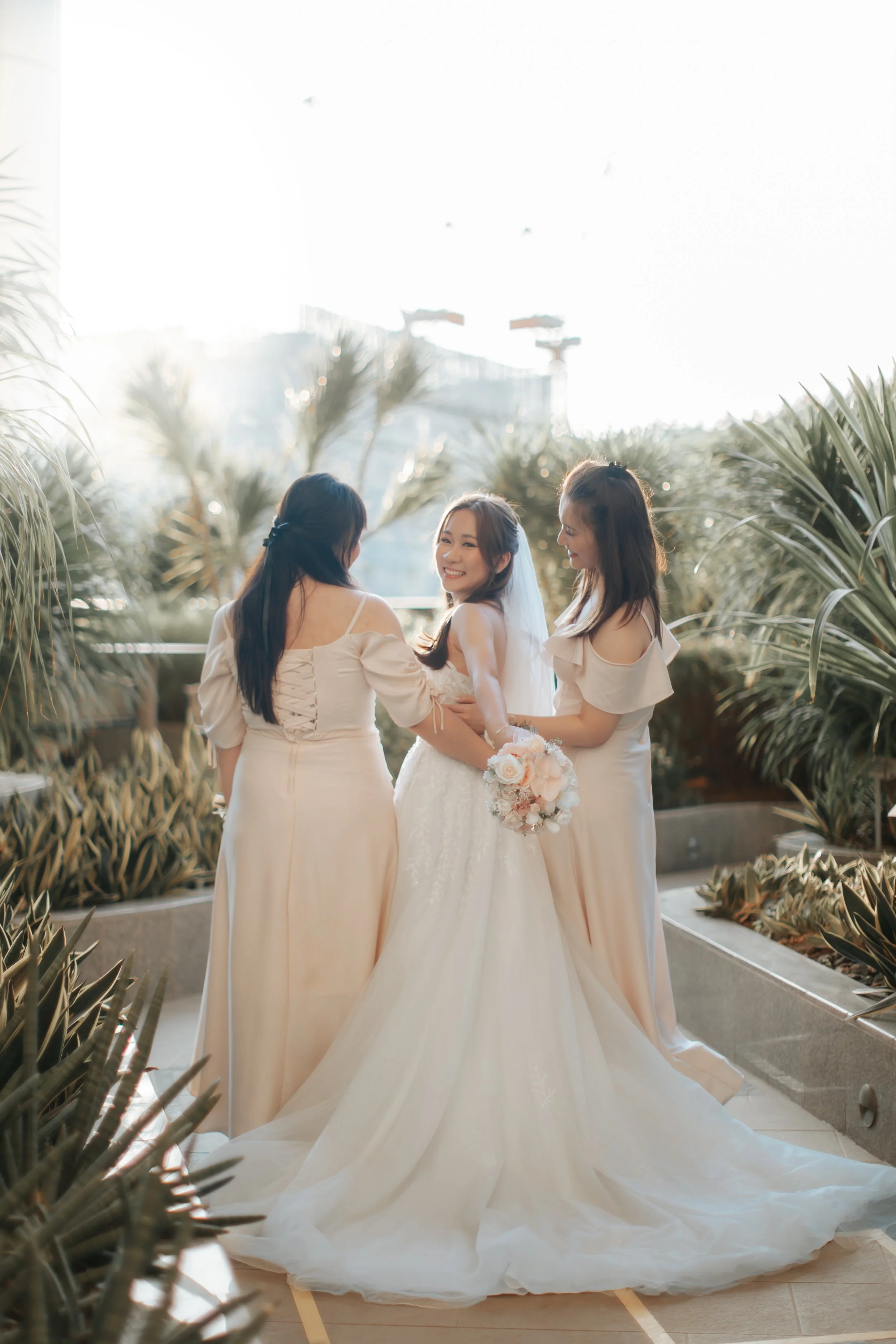Light and airy actual day photoshoot of a bride and her bridesmaids at a garden area. Captured by Arielle for Breadandbutterworks.