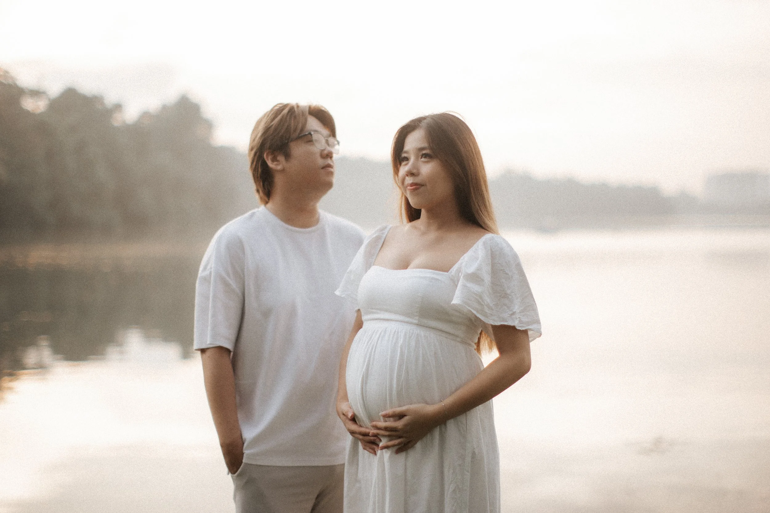 Warm and candid maternity photoshoot, taken during golden hour at Upper Peirce Reservoir. Captured by Breadandbutterworks in a light and airy style.