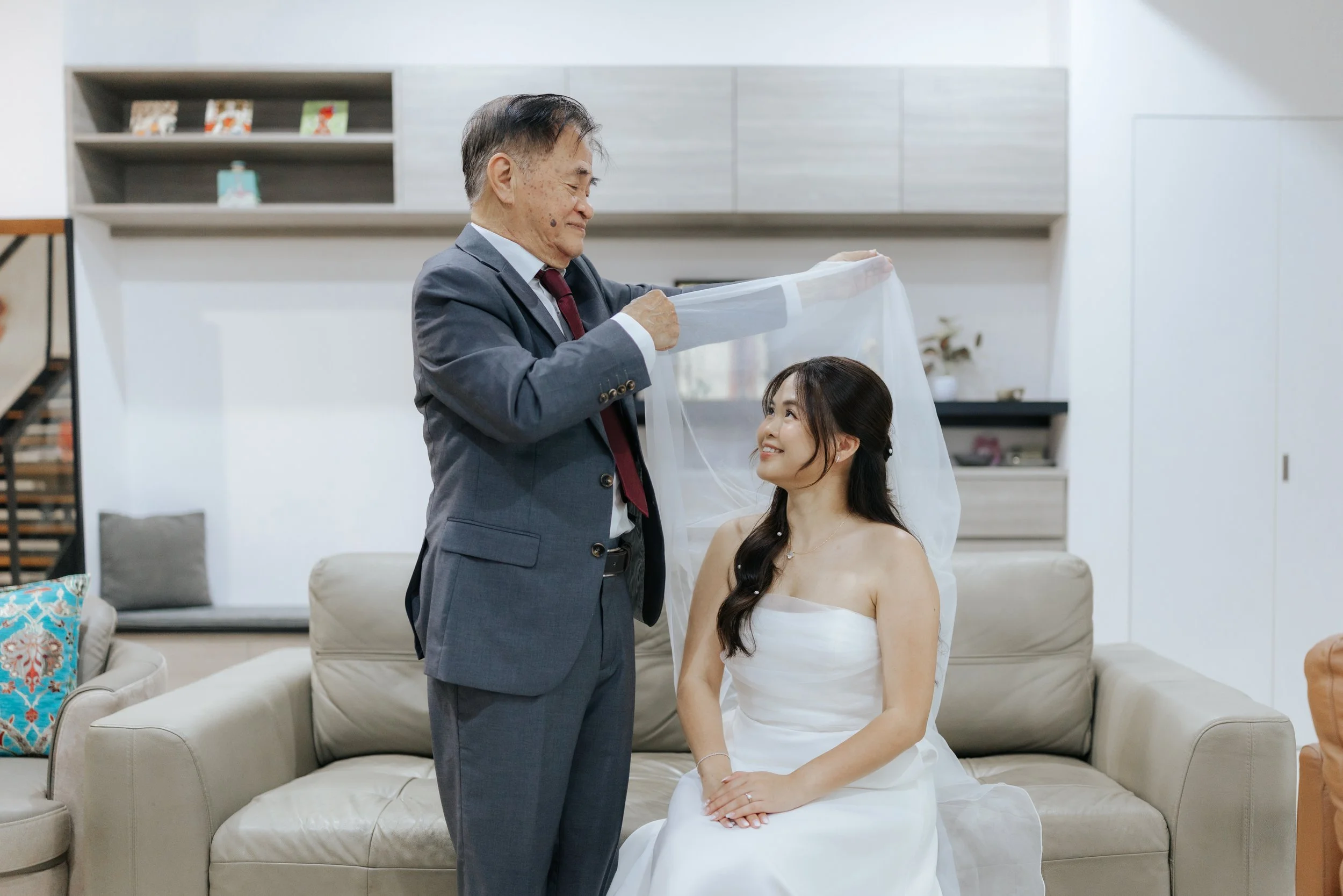 Father of a the bride-to-be veiling his daughter in preparation for her actual day wedding. Photographed by Breadandbutterworks.