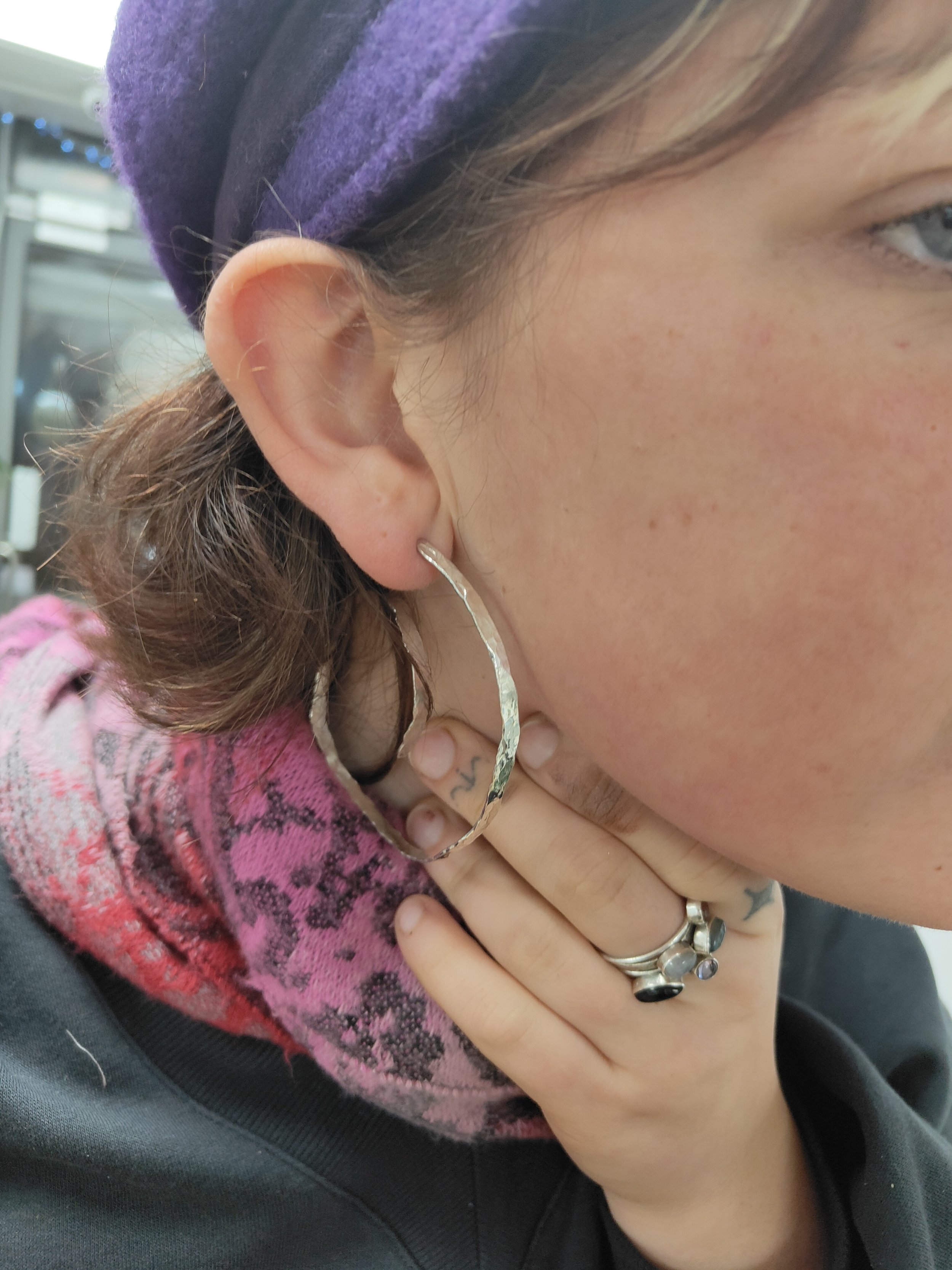 Girl showing off hammered silver hoop earring