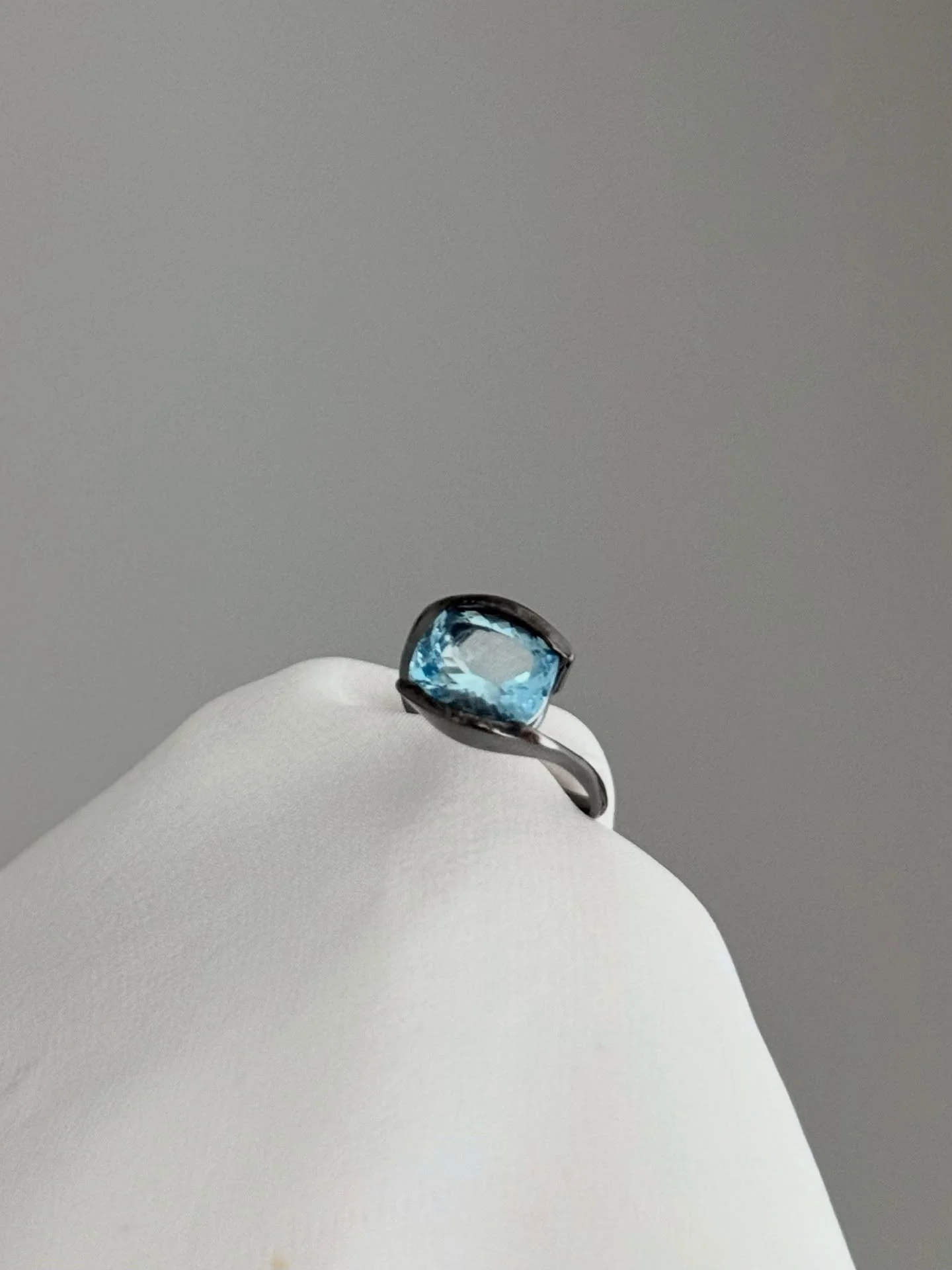 Questo anello &egrave; nato da una visione di contrasto e purezza. Al centro, troneggia una magnifica Acquamarina dal taglio cuscink, che cattura la luce con la freschezza cristallina di un&rsquo;acqua inesplorata.

La gemma &egrave; incastonata in u