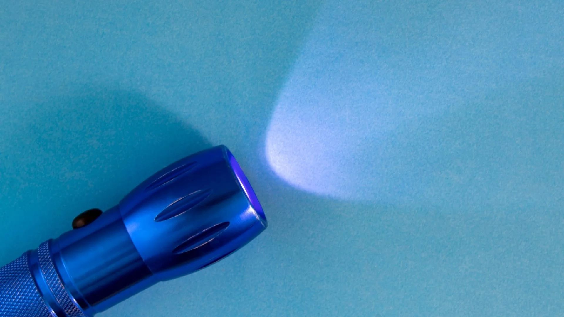 A blue torch shining on a pale blue background