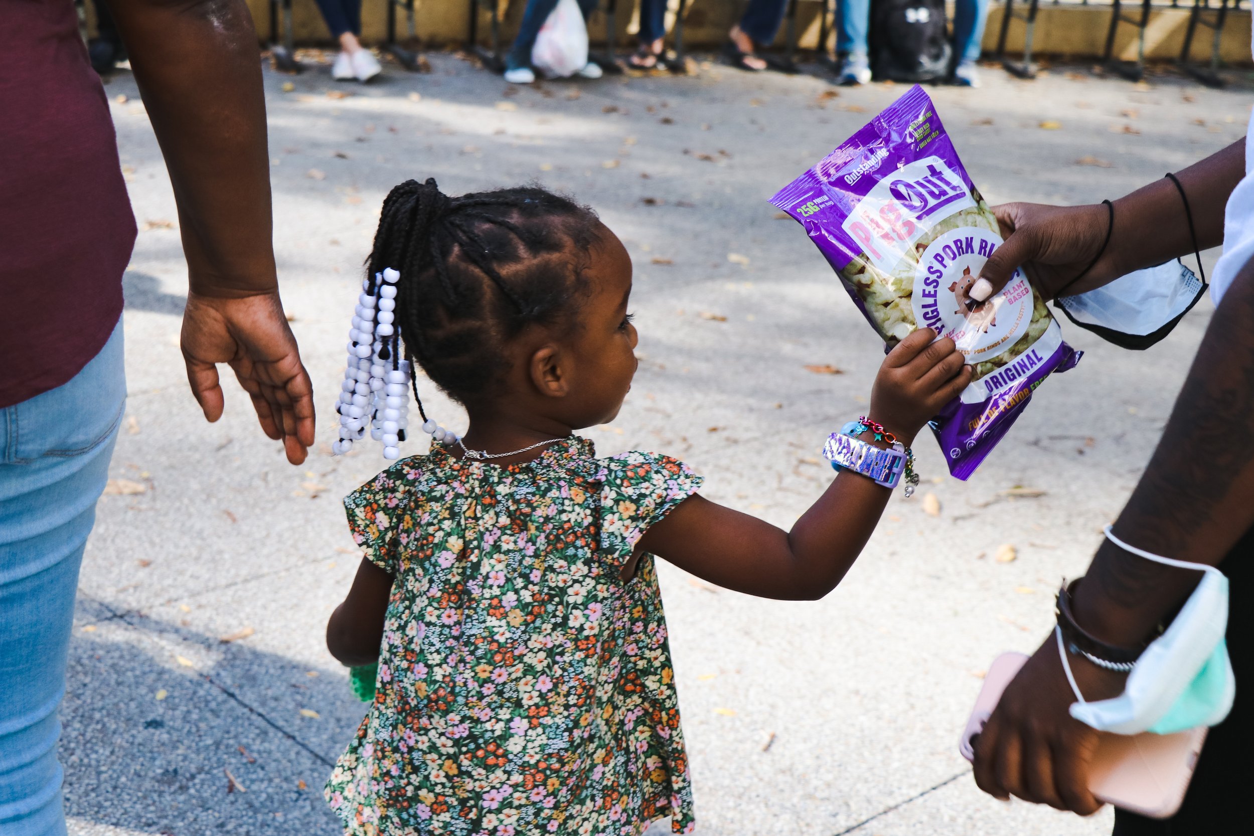 Activists hand out “Pig Out” snacks, a vegan alternative to pork rinds to a young girl. They do this with the intention of “showing that there is always a vegan, cruelty-free alternative out there” says Alyssa Weimer.