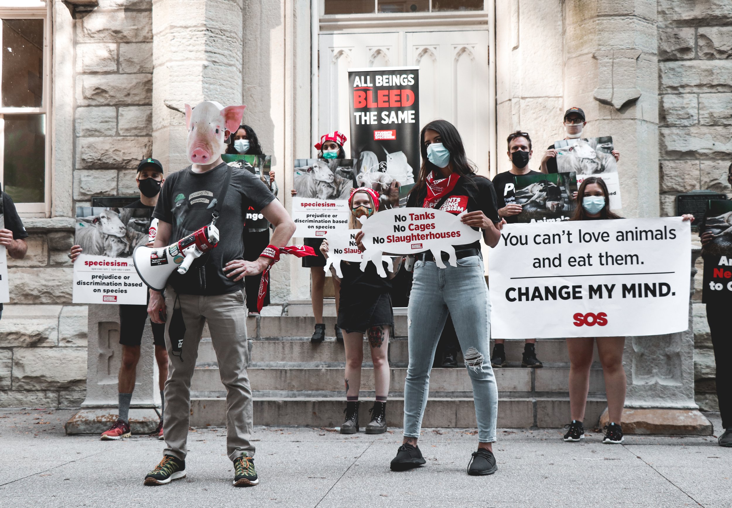 Protesters hold their signs in the park and engage pedestrians as they protest against speciesism. They define it as “prejudice or discrimination based on species,” the belief that all species are equal.