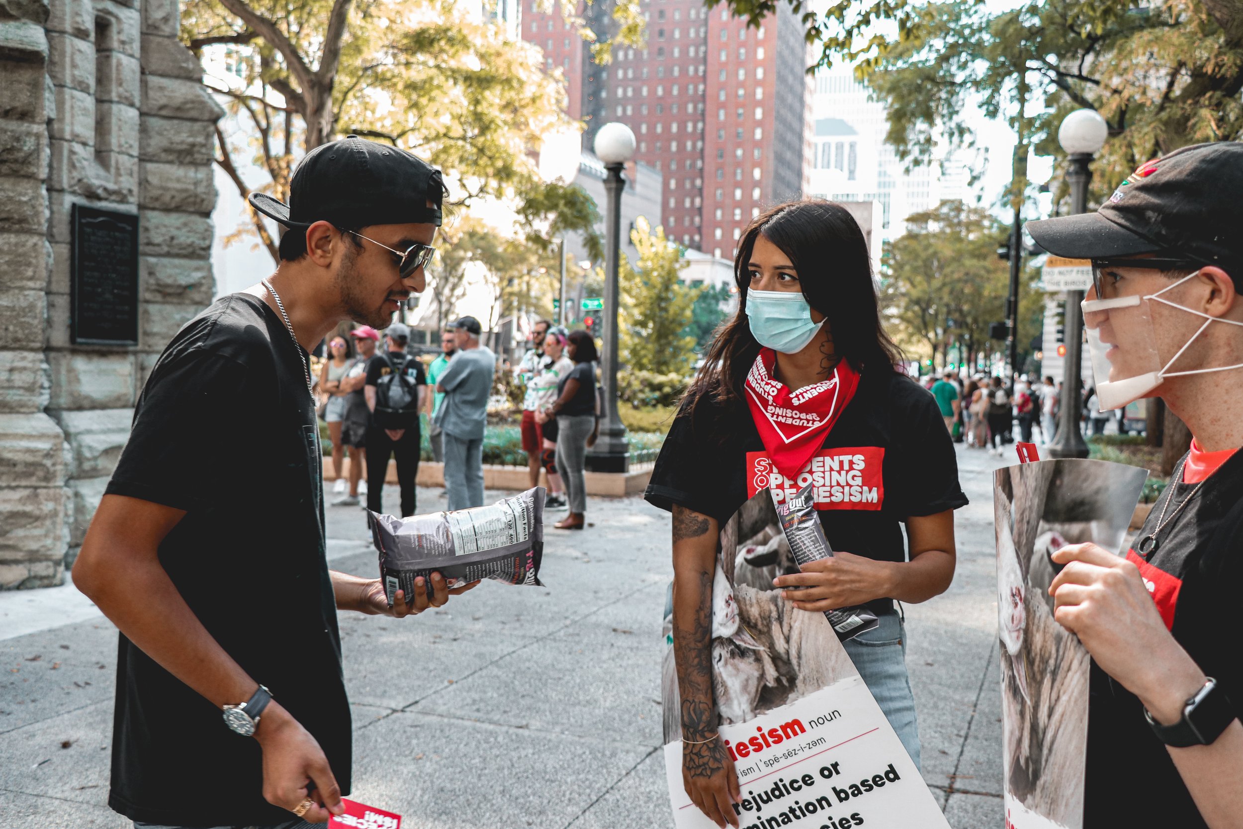 Pedestrians engage with the activists in friendly conversation, asking questions and sharing thoughts.