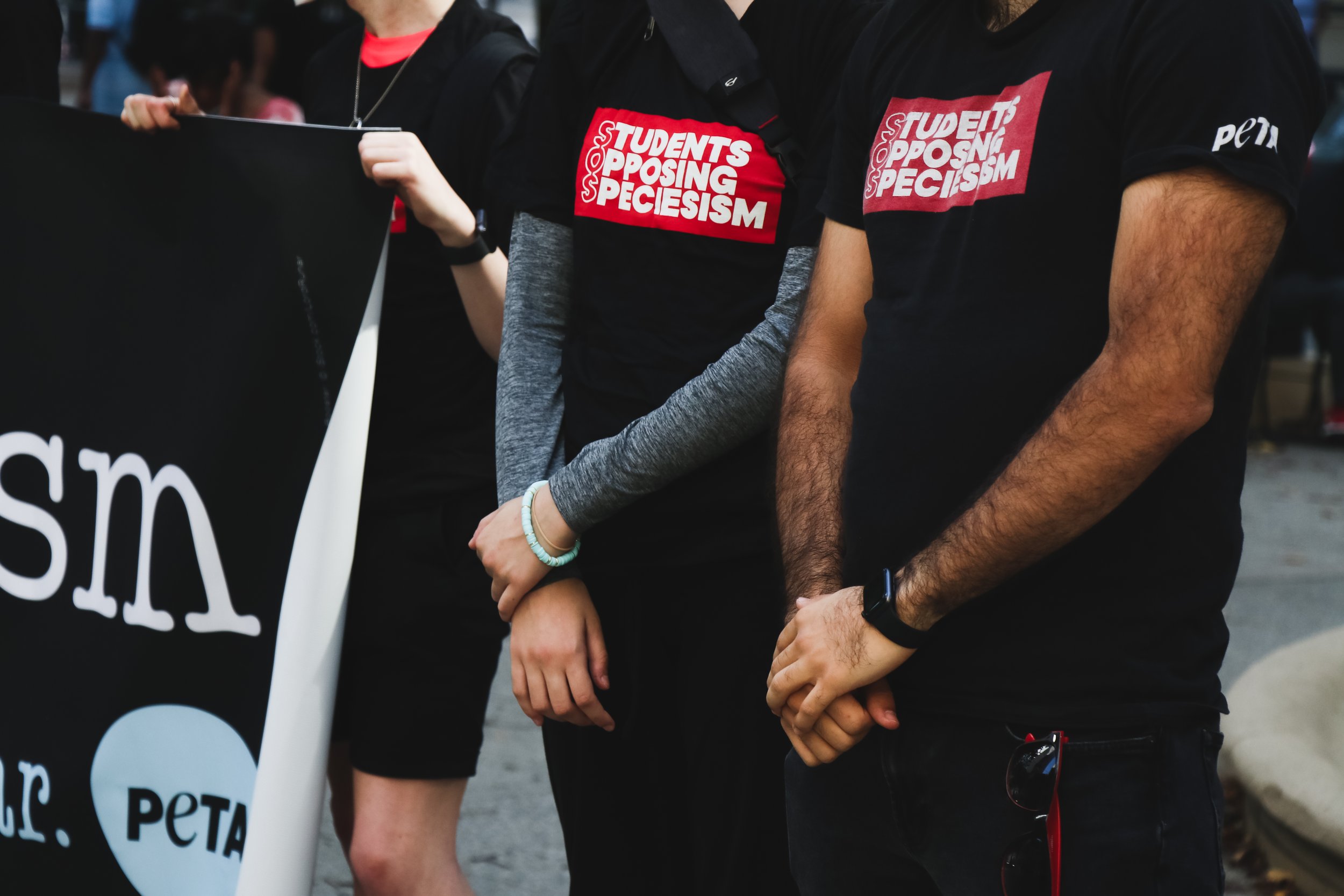 Protesters stand up tall, cross-armed, as they chant “their bodies, not ours… animals are, not ours” to wrap up the protest after around 2 hours of activism at the Water Tower park.