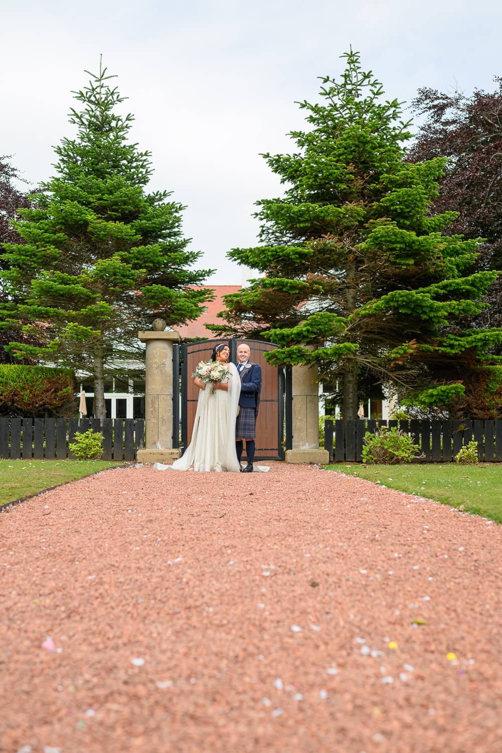Wedding couple on red gravel drive at Lochgreen House Hotel in Troon