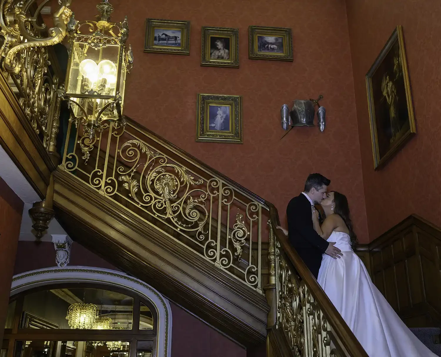 Bride and groom kissing on grand staircase at Auchen Castle wedding venue in Moffat