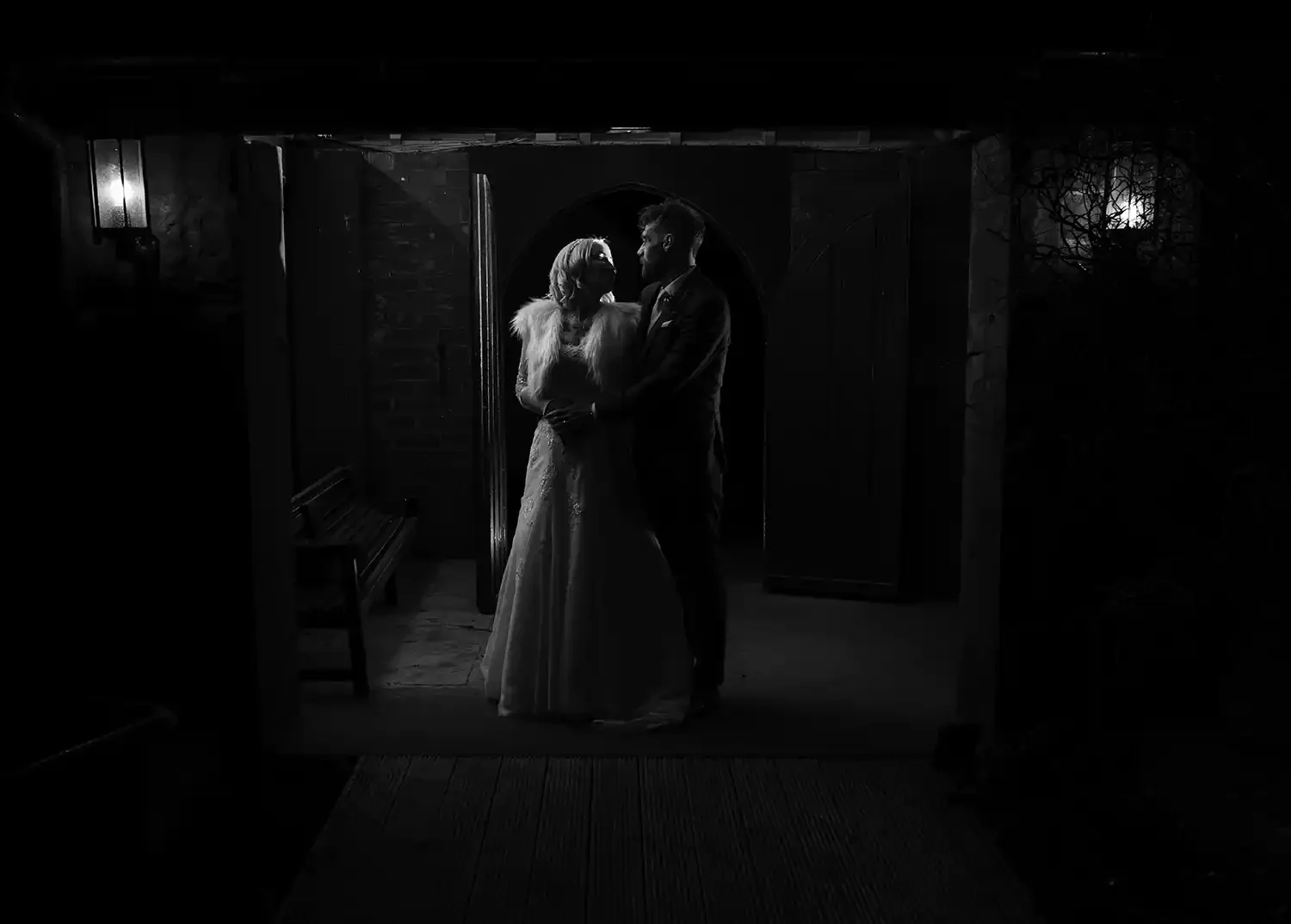Bride and groom embracing in doorway at Piersland House Hotel in Troon at night