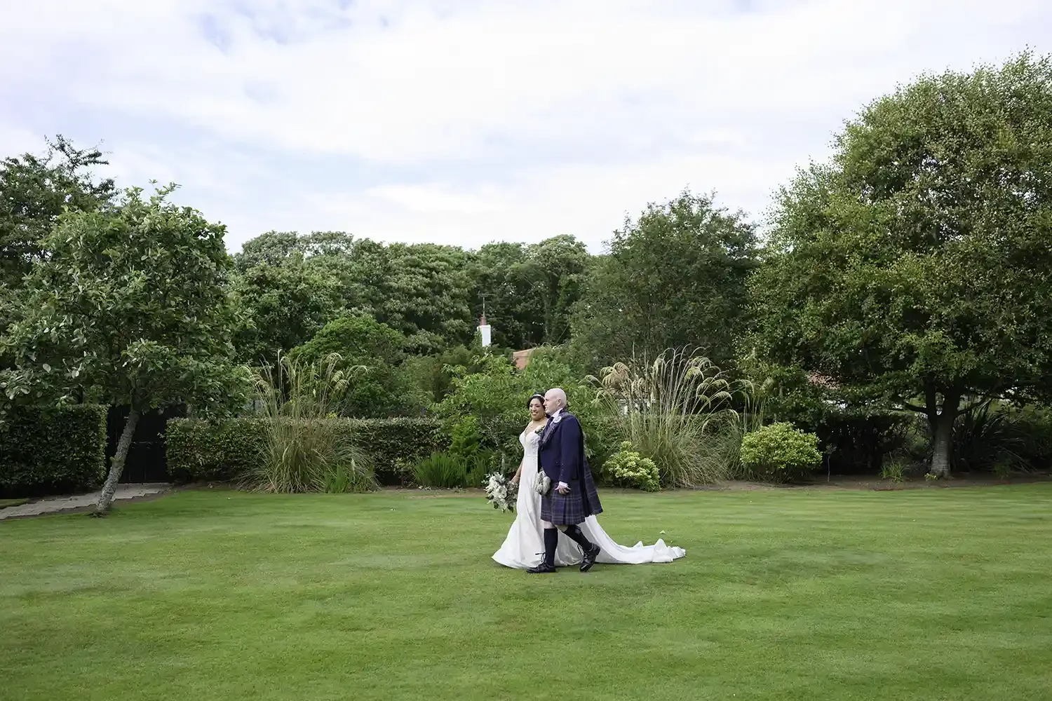 Bride and groom walking through the gardens at Lochgreen House Hotel wedding venue in Troon Ayrshire