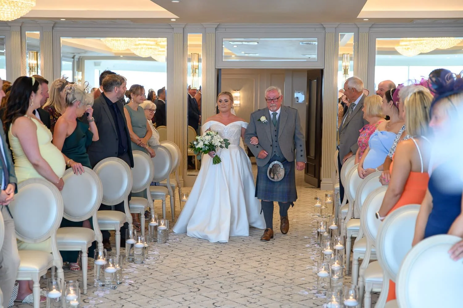 Bride walking down the aisle during her wedding ceremony at Seamill Hydro Hotel in West Kilbride.