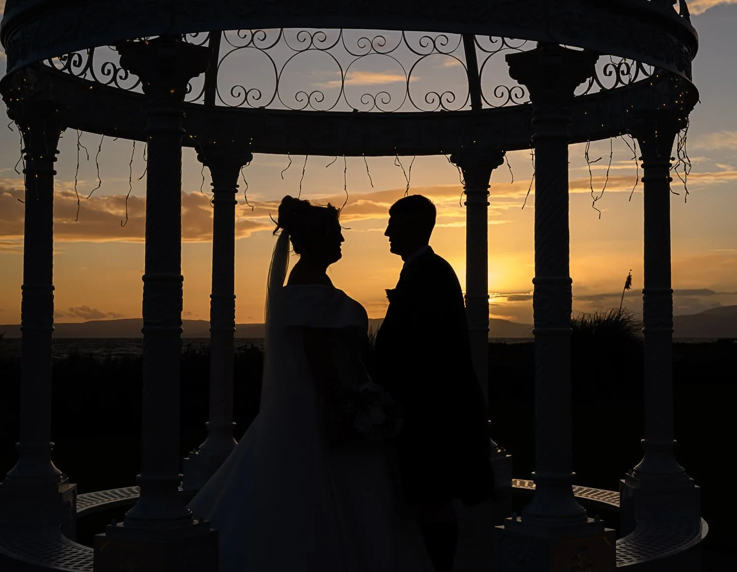 As the sun set over The Waterside, this couple stole a quiet moment beneath the gazebo. Framed against the warm Ayrshire sky, their silhouette creates a timeless and intimate portrait — a reminder that some of the most powerful moments happen in the 