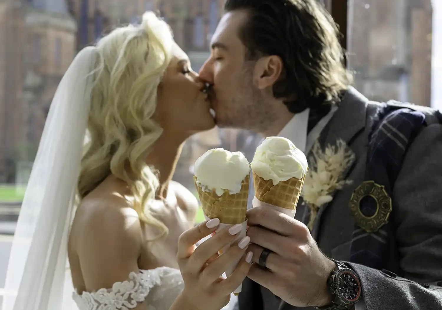 Bride and groom kissing while holding ice cream at Brisbane House Hotel in Largs