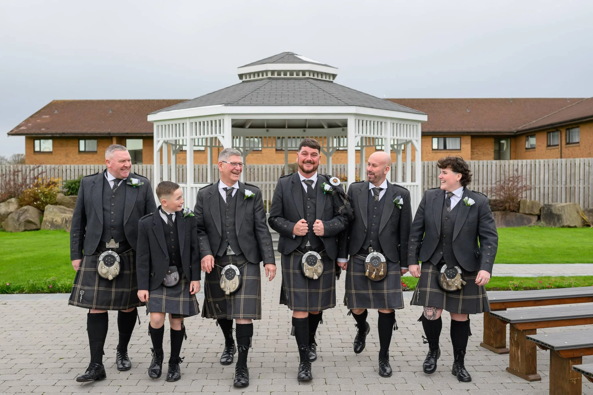 Groom and groomsmen walking together outside Riverside Lodge Hotel in Irvine before the wedding ceremony