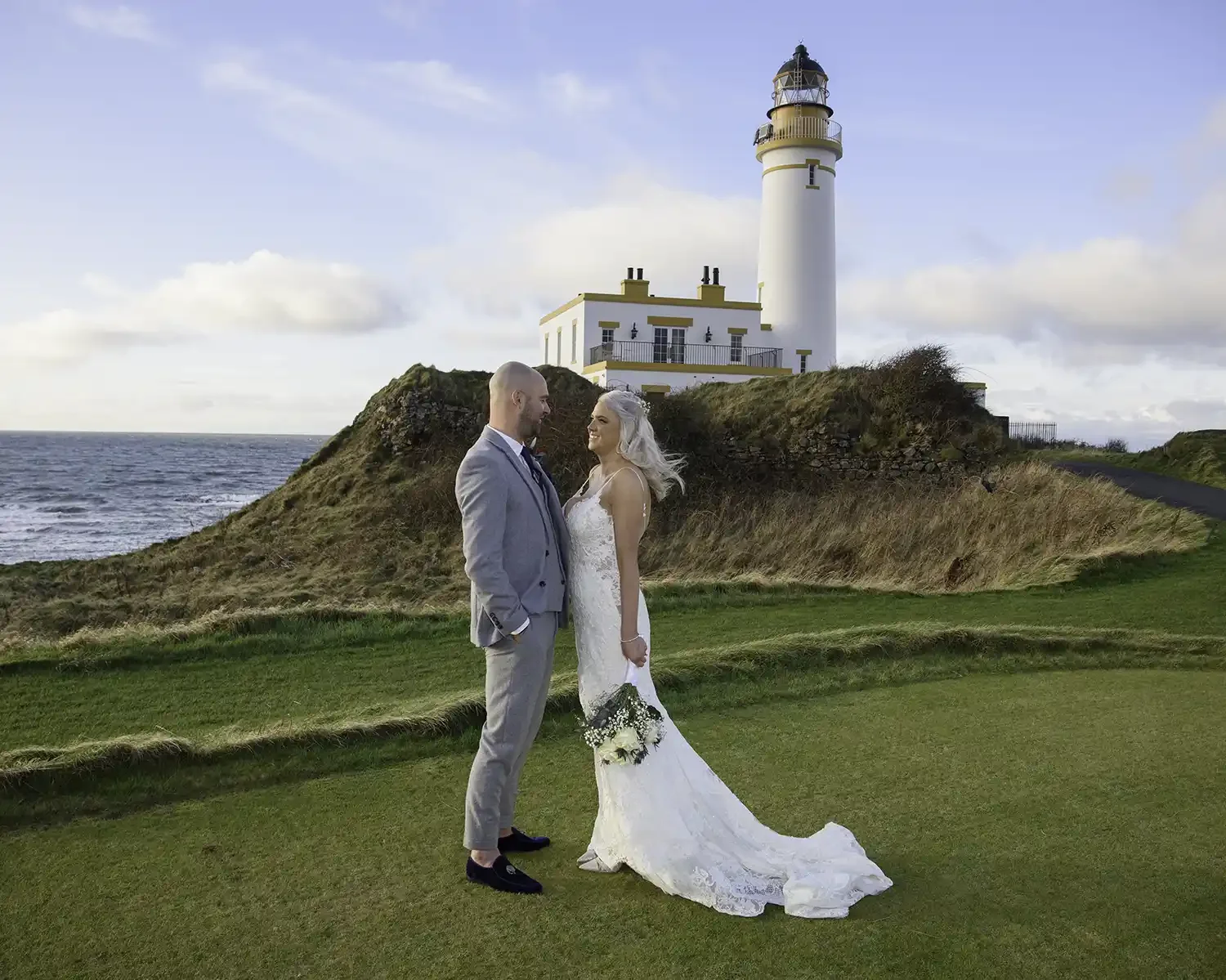 Bride and groom at Turnberry Lighthouse in Turnberry with coastal view