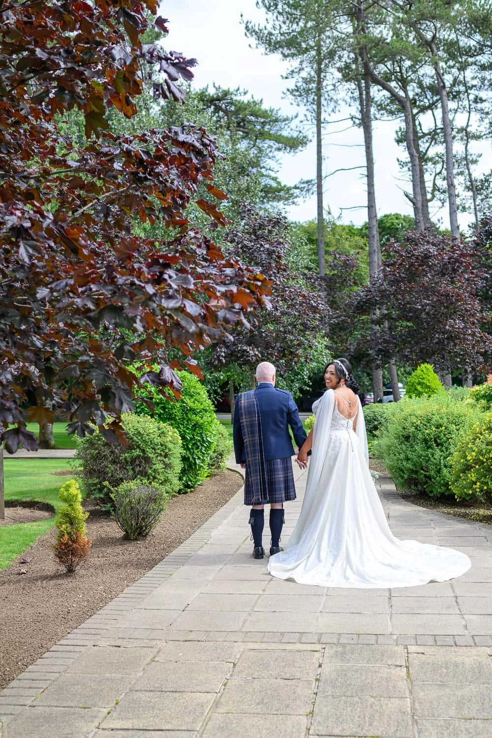 Bride and groom walking through gardens at Lochgreen House Hotel Troon