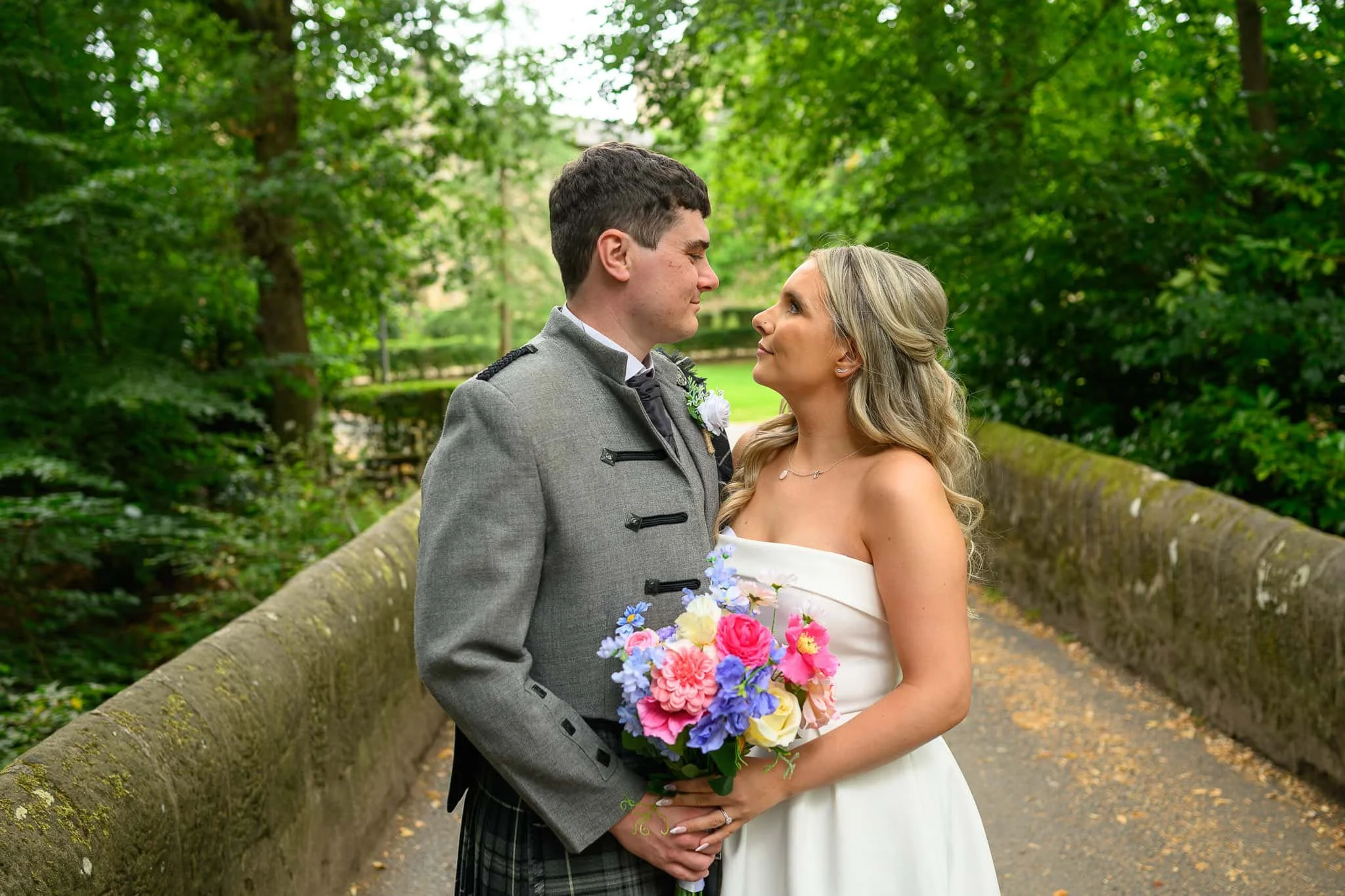 Bride and groom portrait on stone bridge at Dean Castle Country Park wedding in Kilmarnock Ayrshire