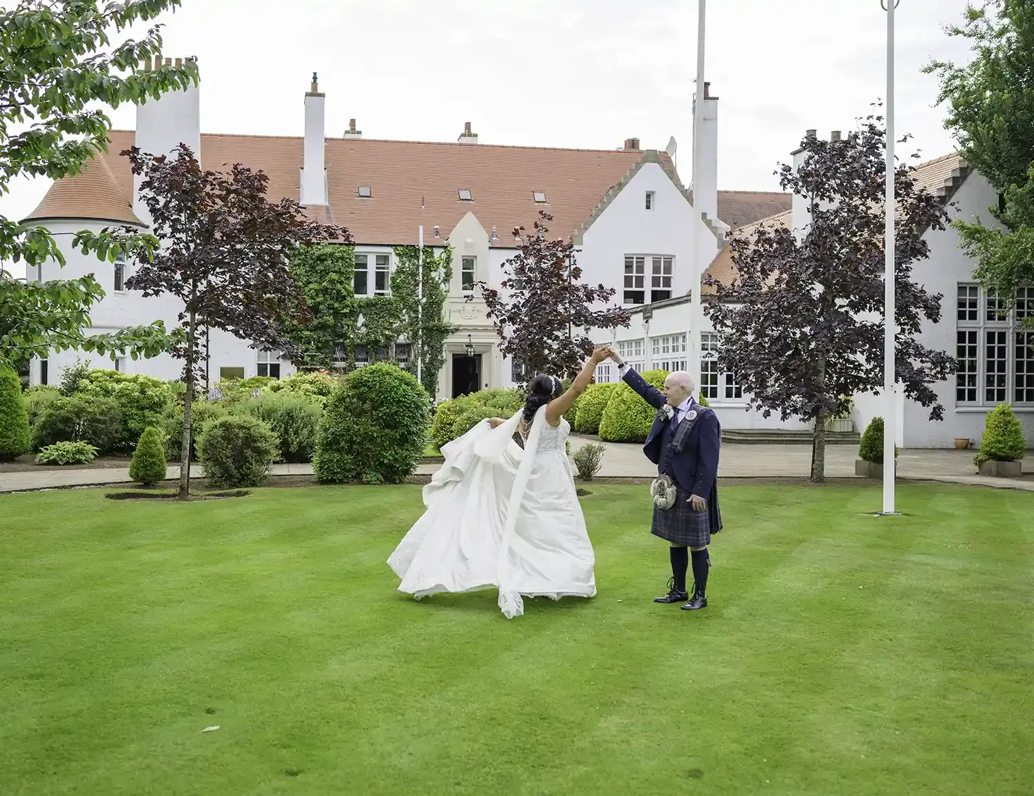 Couple twirling on the lawn at Lochgreen House Hotel in Ayrshire