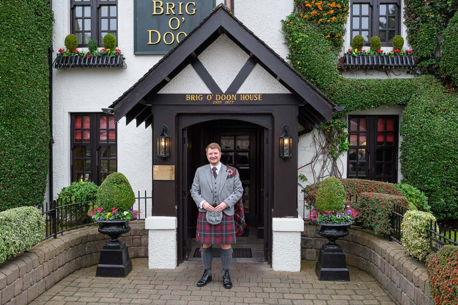 Groom standing outside the entrance of Brig O'Doon House Hotel in Alloway Ayr on his wedding day
