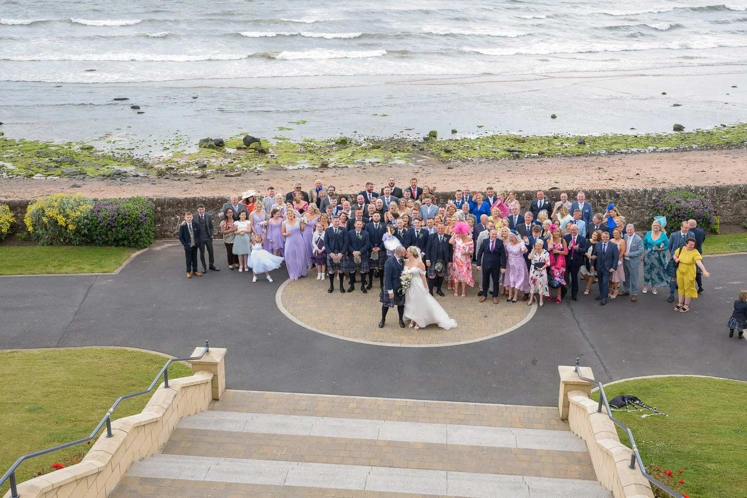 Large wedding group photo taken outside at the back of Seamill Hydro Hotel overlooking the beach in West Kilbride.