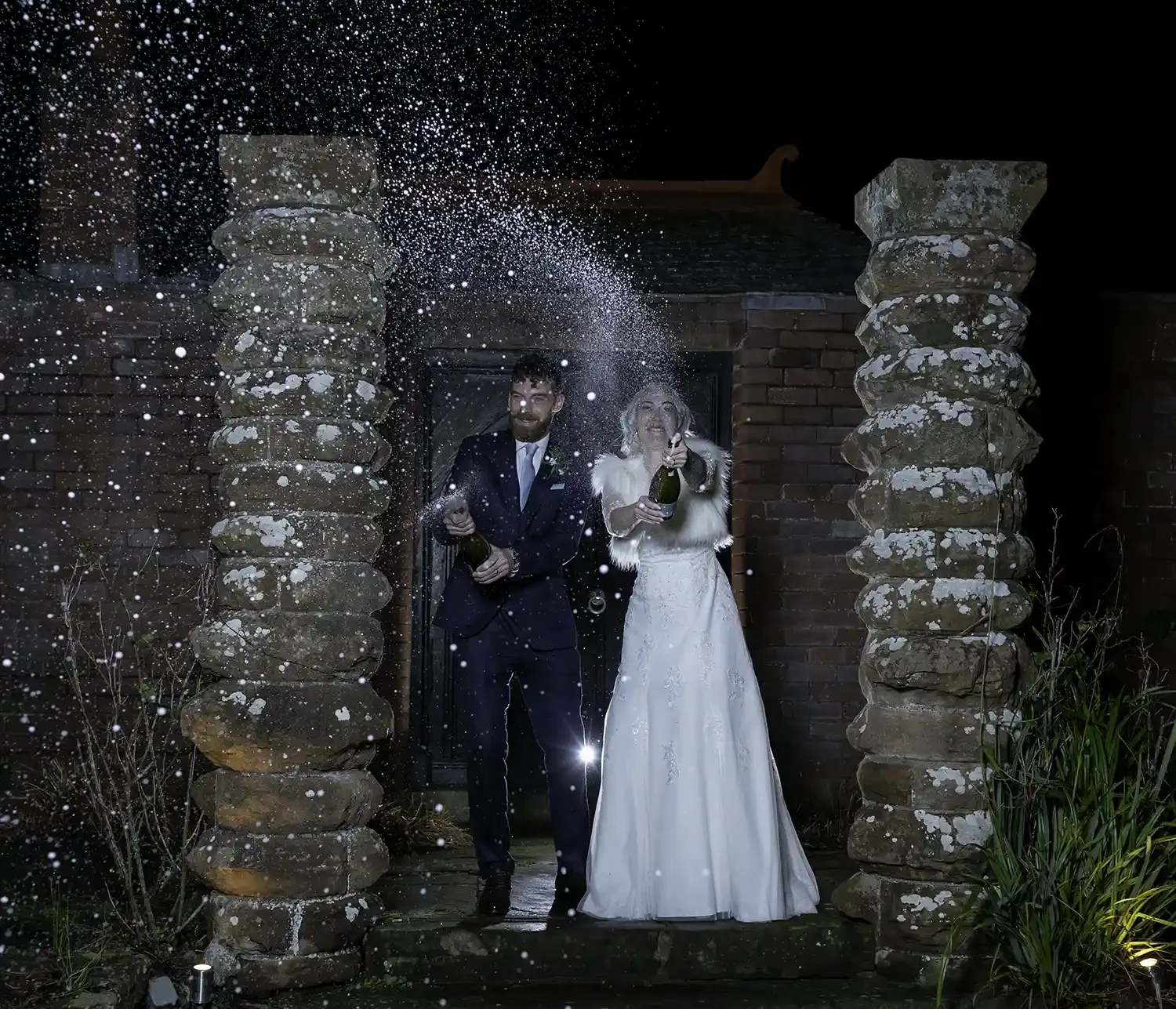 Bride and groom spraying champagne at night at Piersland House Hotel in Troon