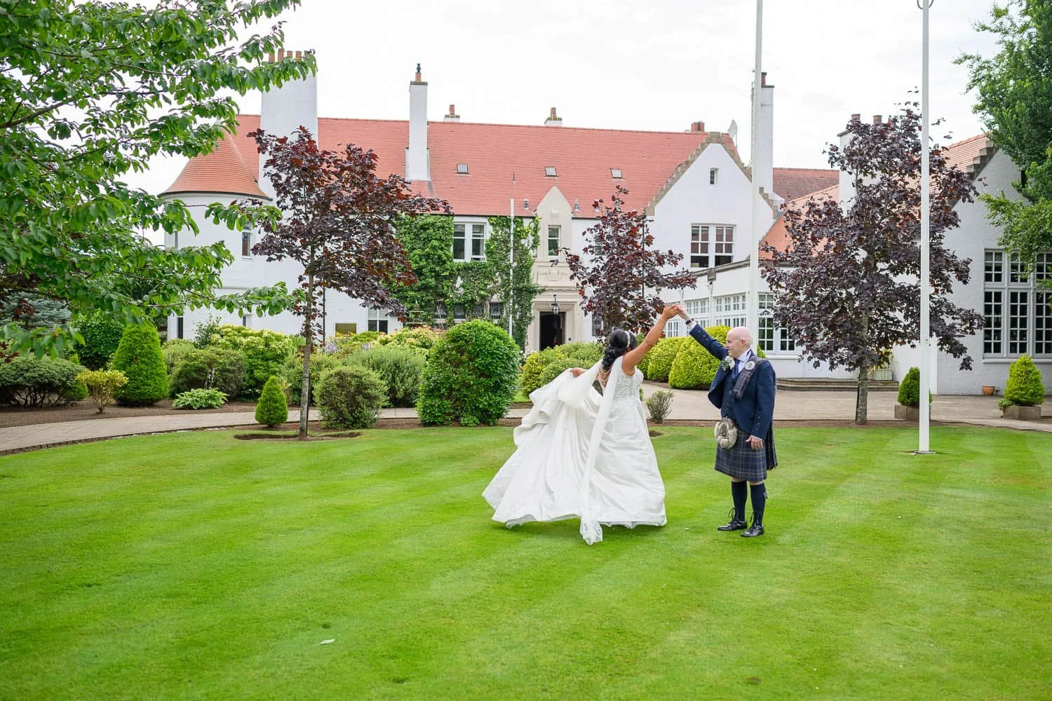 Couple twirling on the lawn at Lochgreen House Hotel in Ayrshire