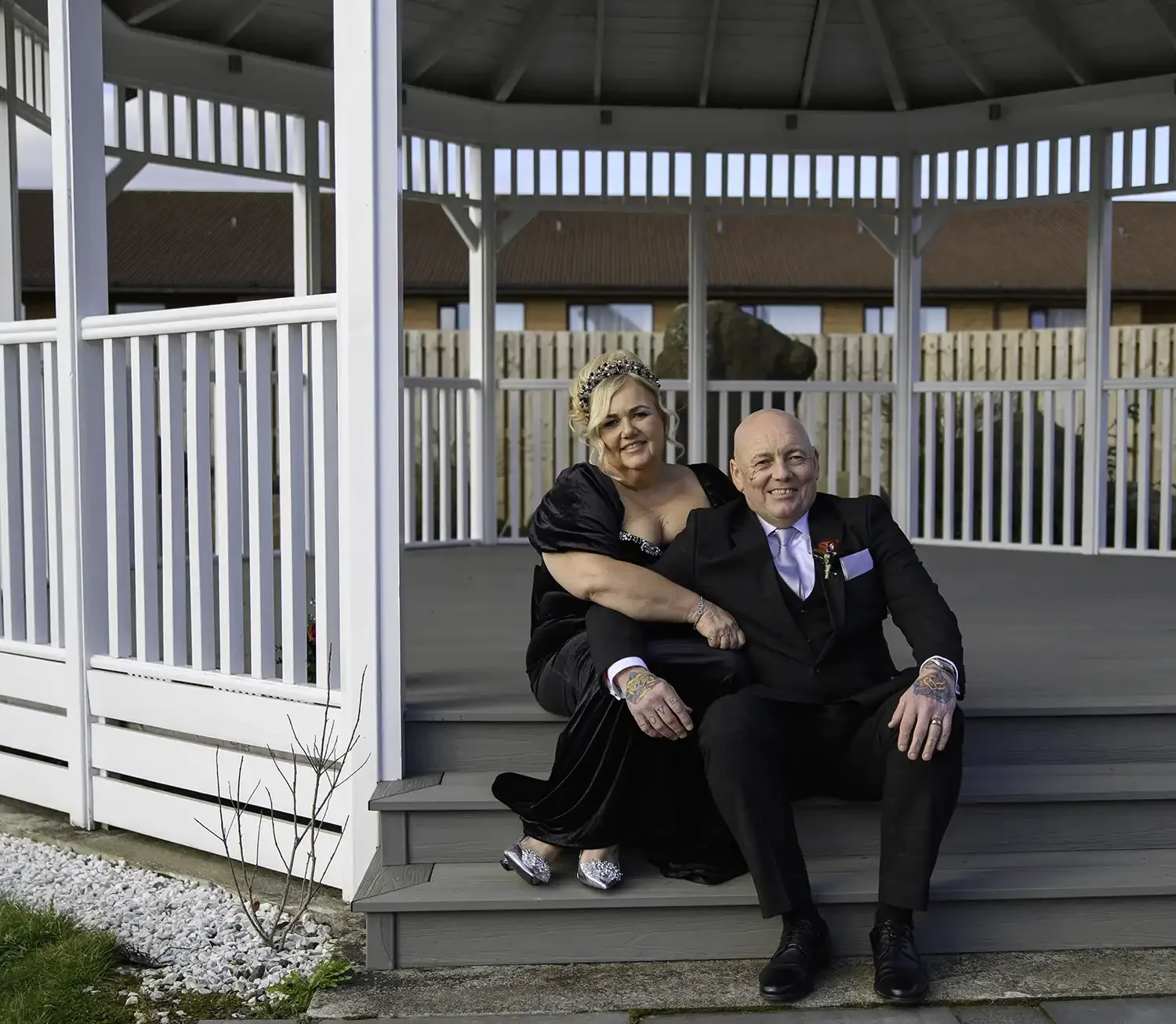 Morag and Jeff sitting together in a white gazebo at Riverside Lodge Hotel during their wedding day in Ayrshire.
