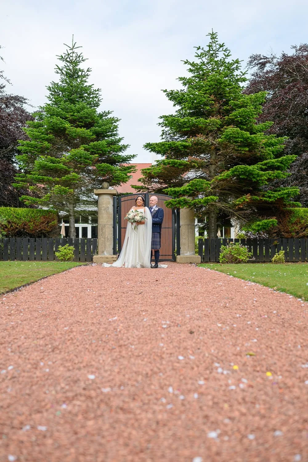 Bride and groom at entrance gates of Lochgreen House Hotel in Troon