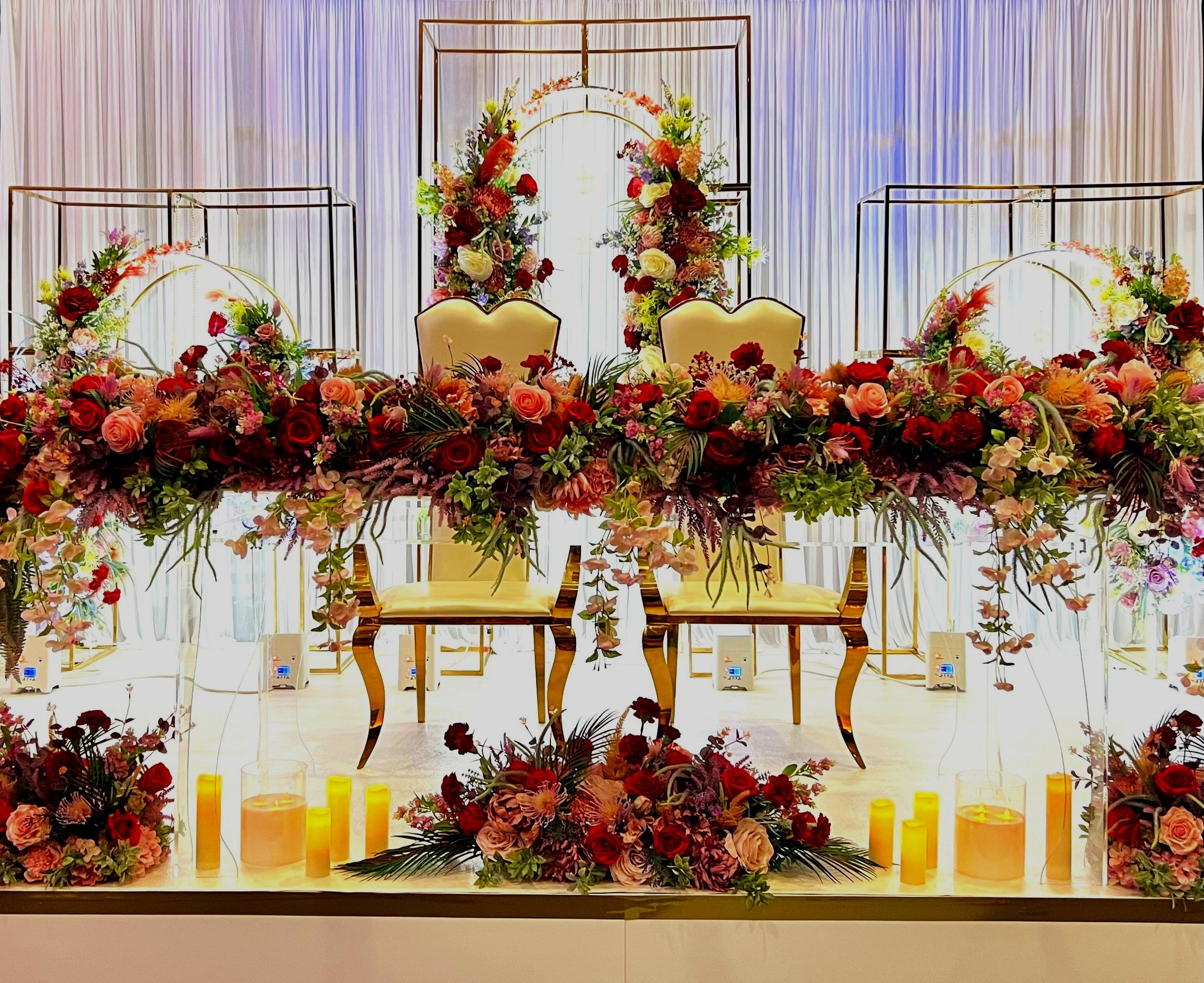  Top Table at a recent Indian Wedding, decorated with pink and red flower arrangements. 