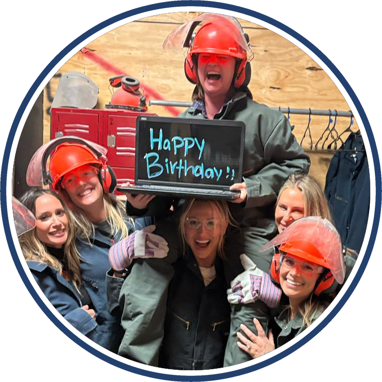 Birthday girl gets a lift with her friends in the rage room while holding a happy birthday sign.