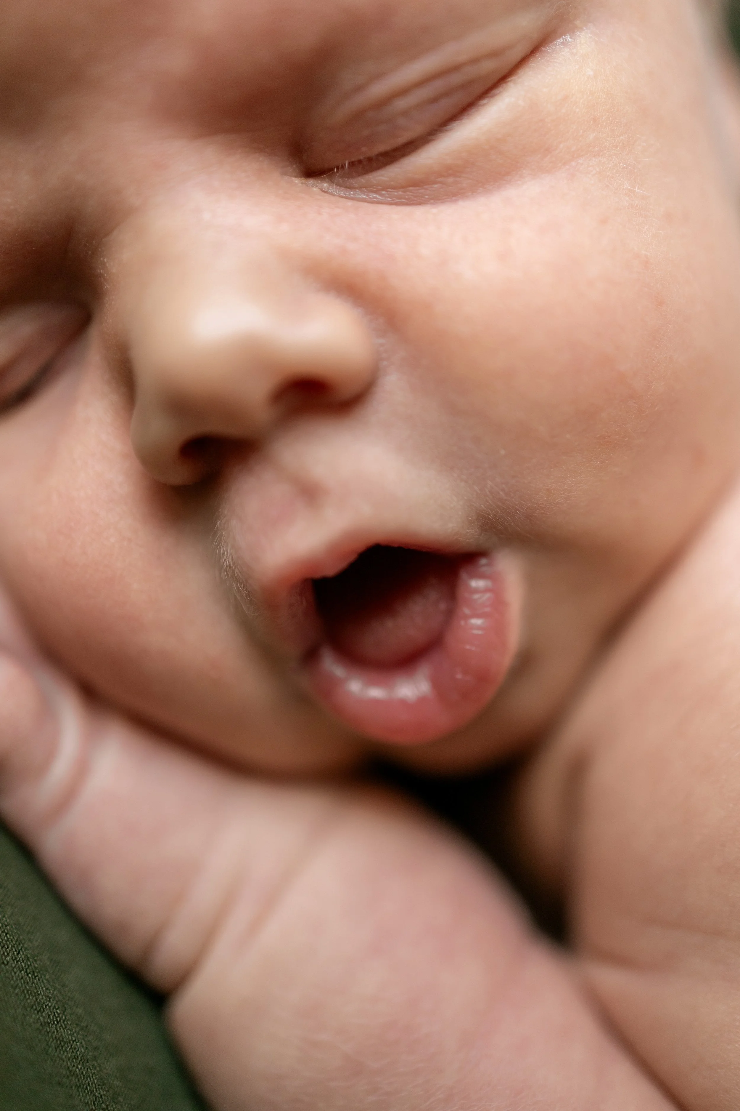Close-up of a sleeping baby's face showing closed eyes, nose, and slightly open mouth.