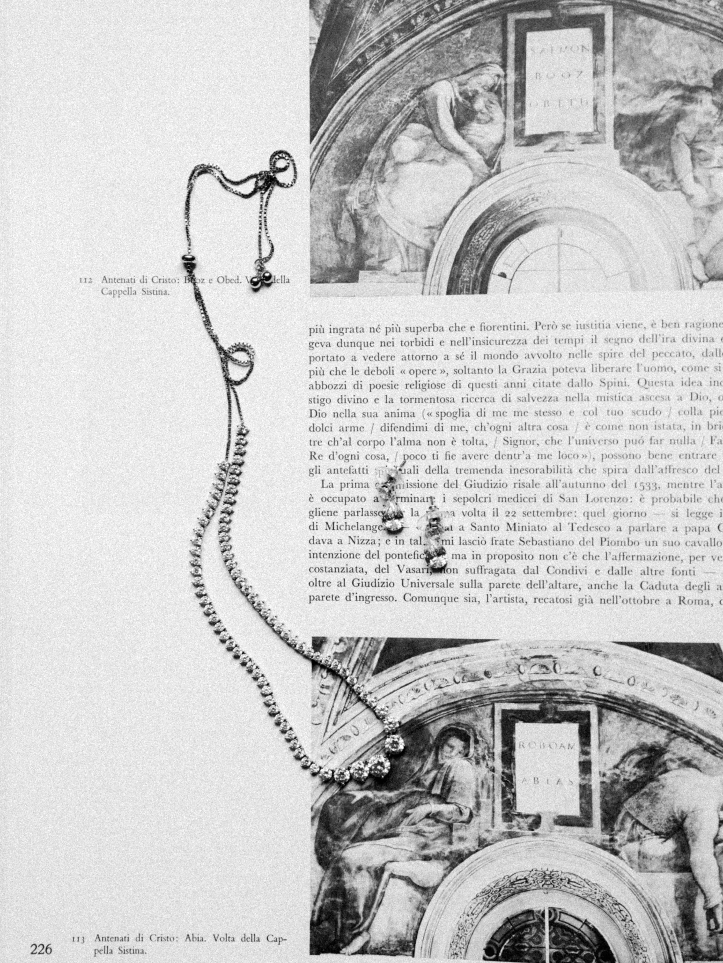Black-and-white photograph of antique religious jewelry placed on an open book with Italian text, with parts of architectural drawings or frescoes visible in the background.