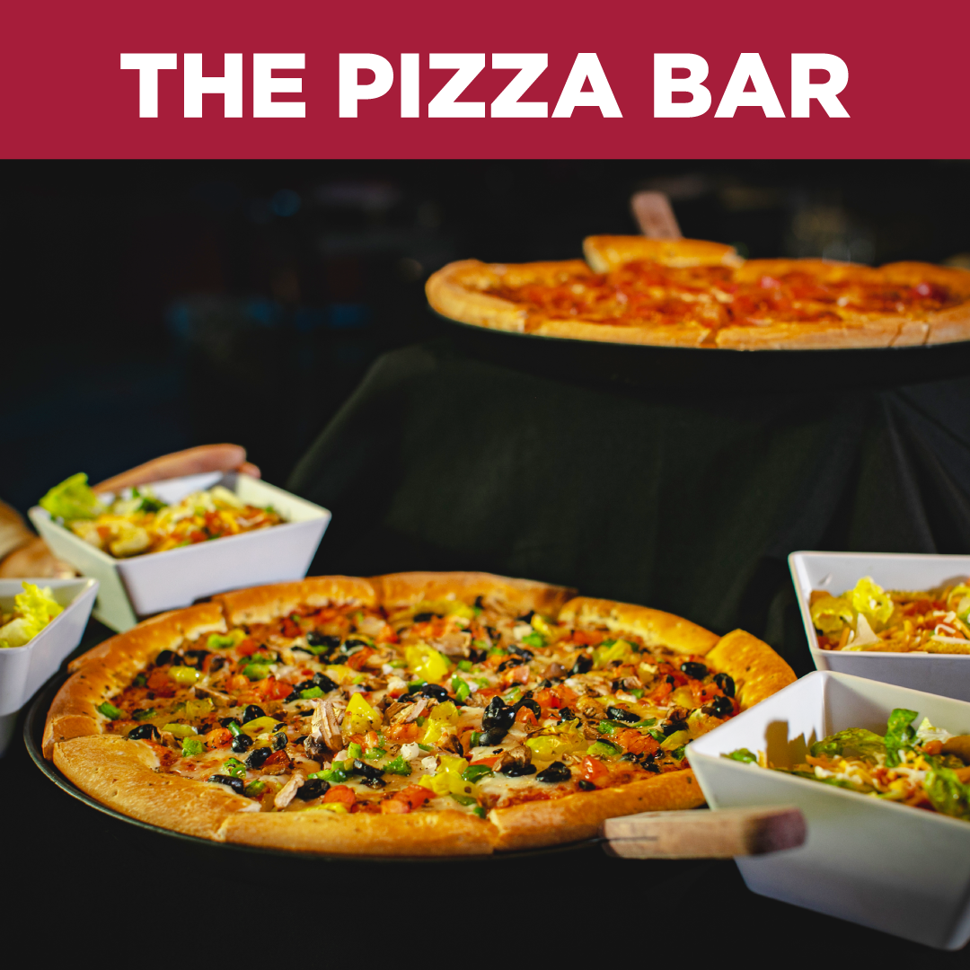 Tray of tacos with shredded meat, onions, and cilantro, served with potato chips and a small bowl of salsa, alongside a tall glass of beer on a wooden table in a restaurant setting.