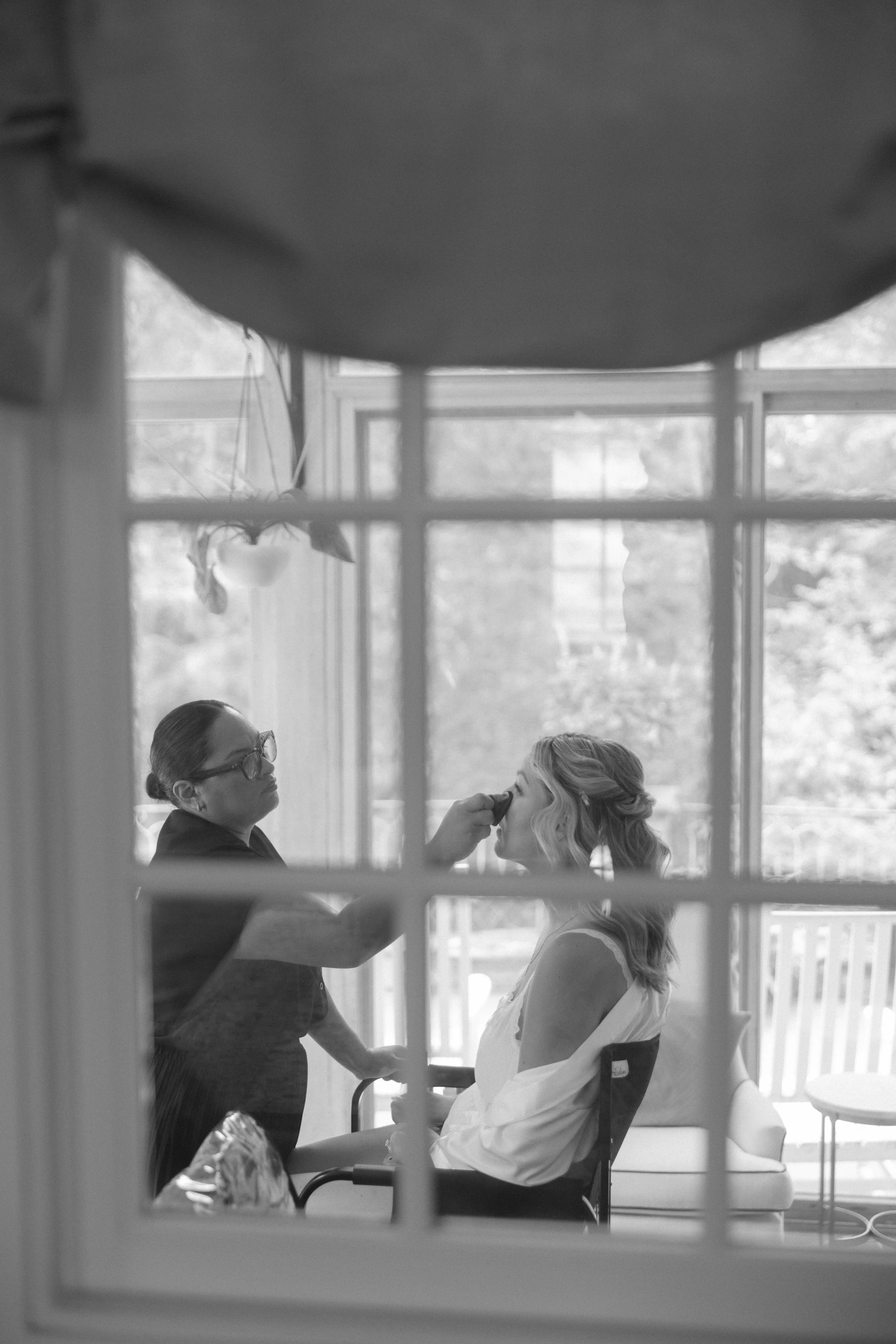 A bride having makeup done in the Historic Home. 
