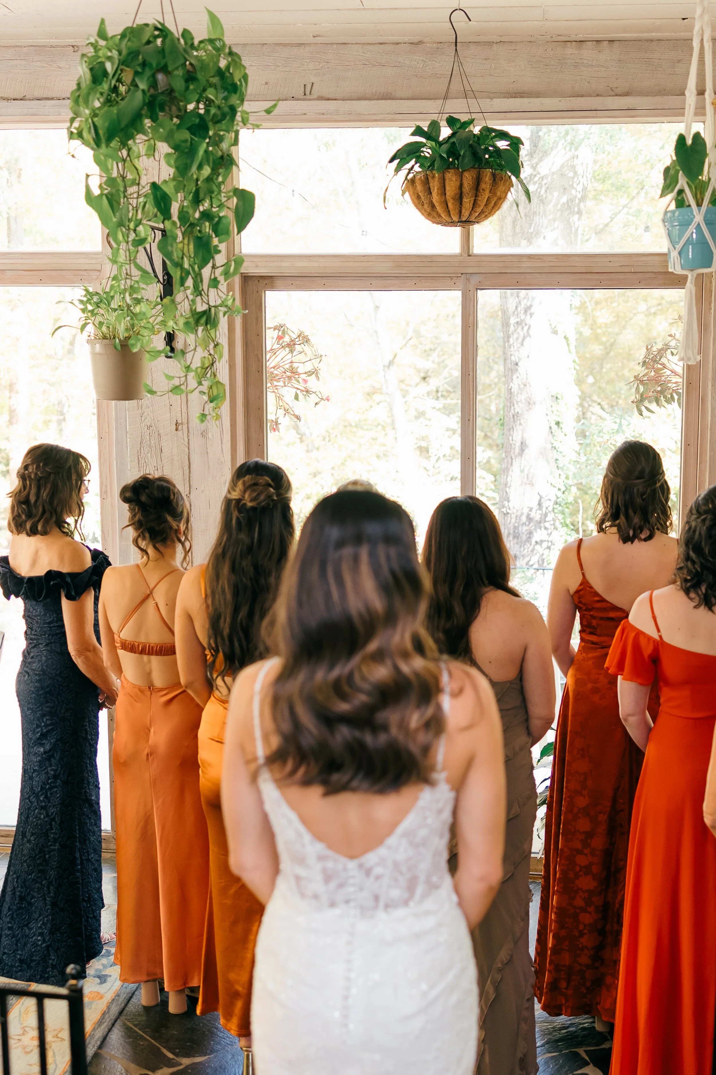 Bridesmaids are about to see the bride in her dress for the first time.  Everyone is waiting in the sunroom of the Historic Home