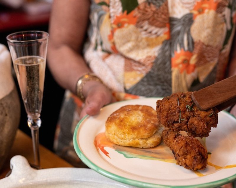 Plate of fried chicken and biscuits with sparkling wine