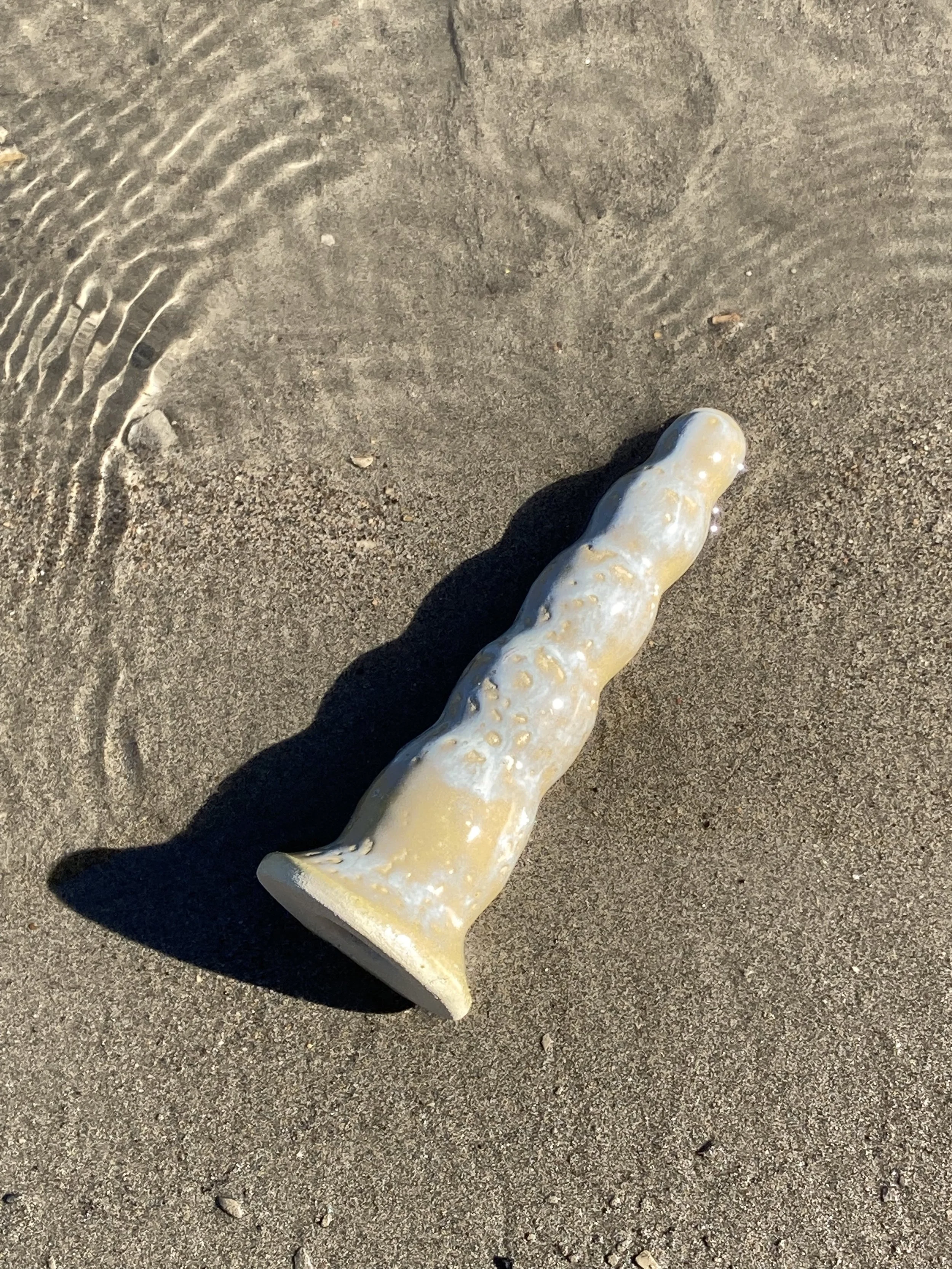 Wavy curvy ceramic dildo on the beach
