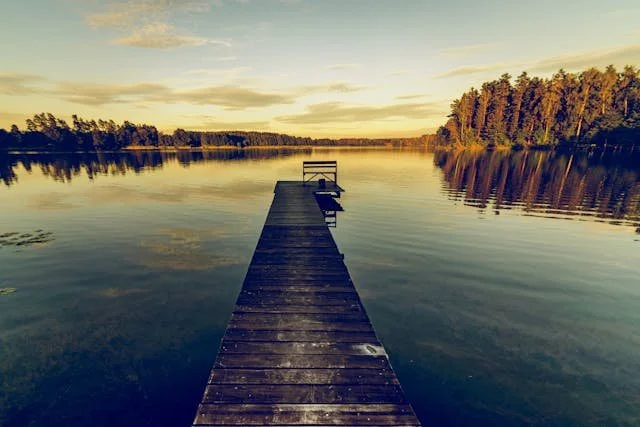 A picture of a dock on a lake in the calm morning hours