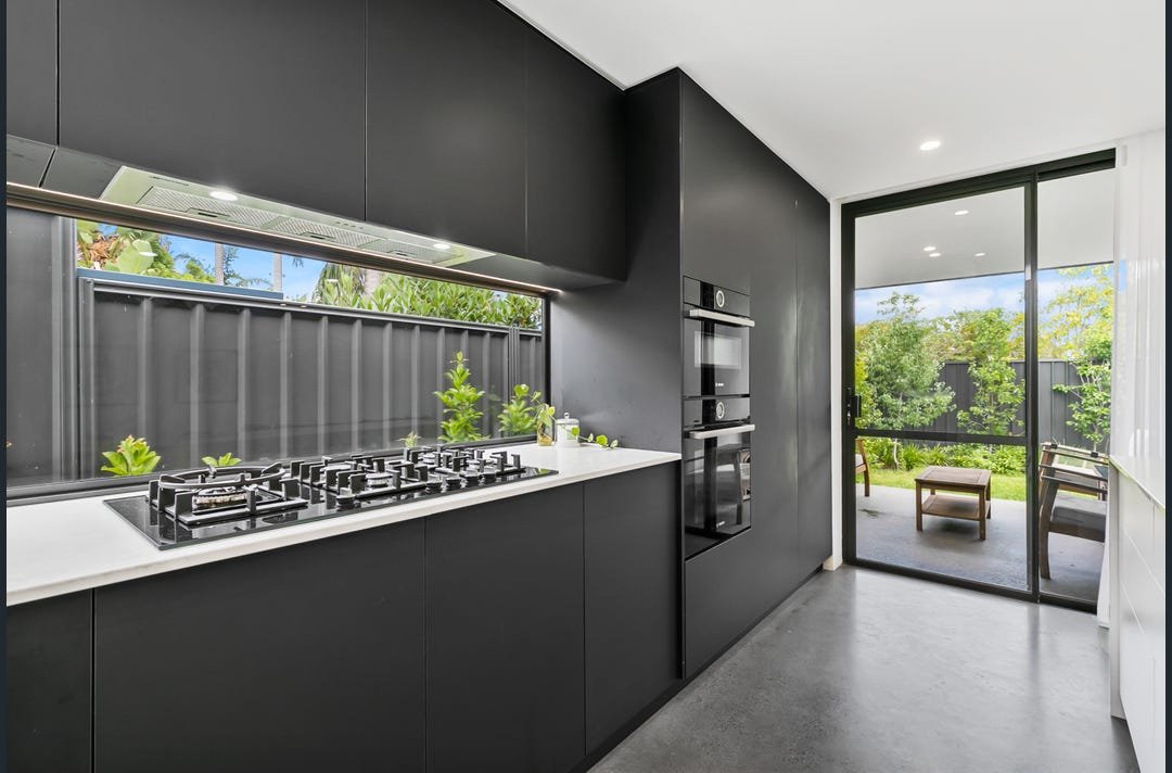 Black kitchen with window splash back