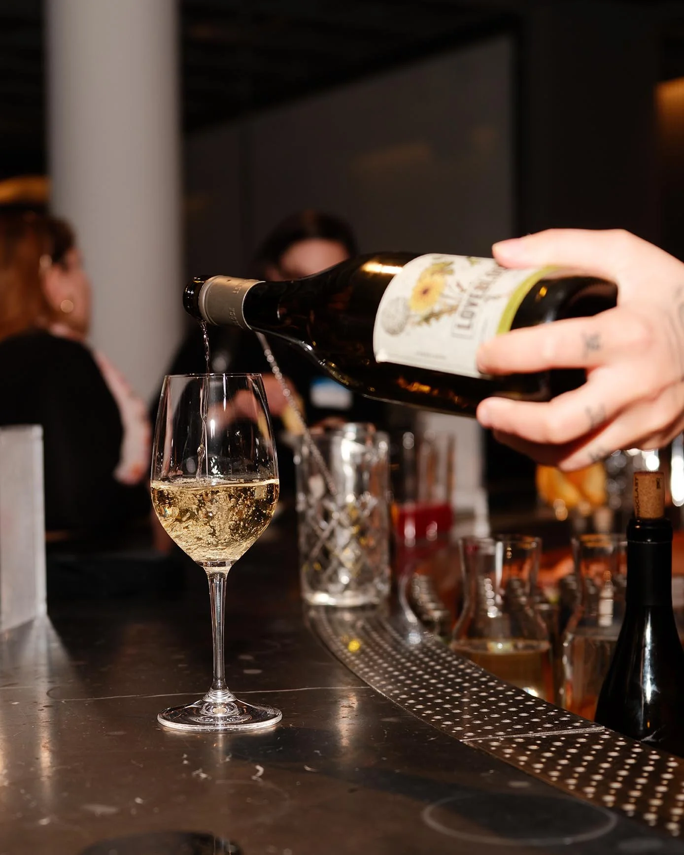 Close-up of white wine being poured into a glass at a bar