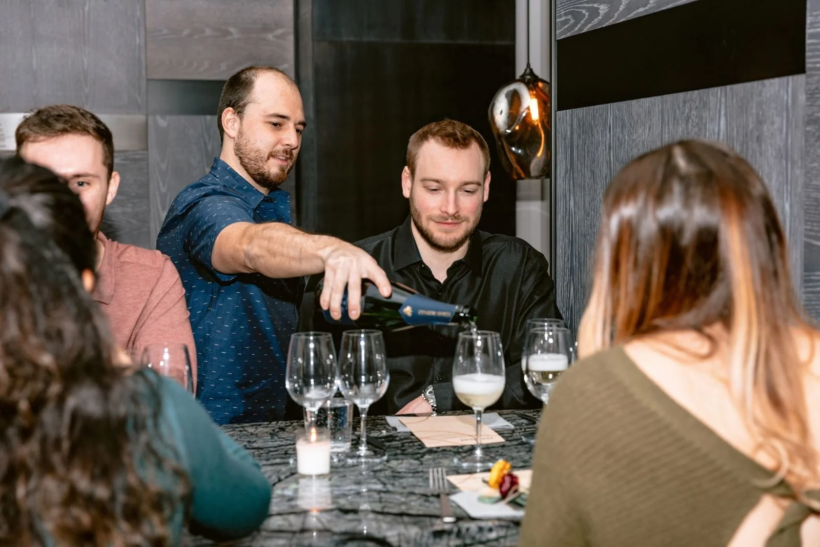 Waiter pouring a glass of champagne for a guest at a Resident private event in New York City