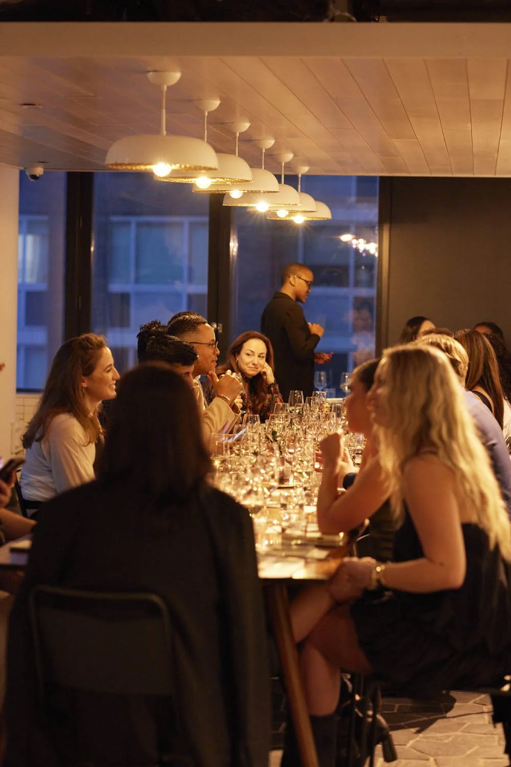 Guests enjoying conversation and wine at an intimate private dining table