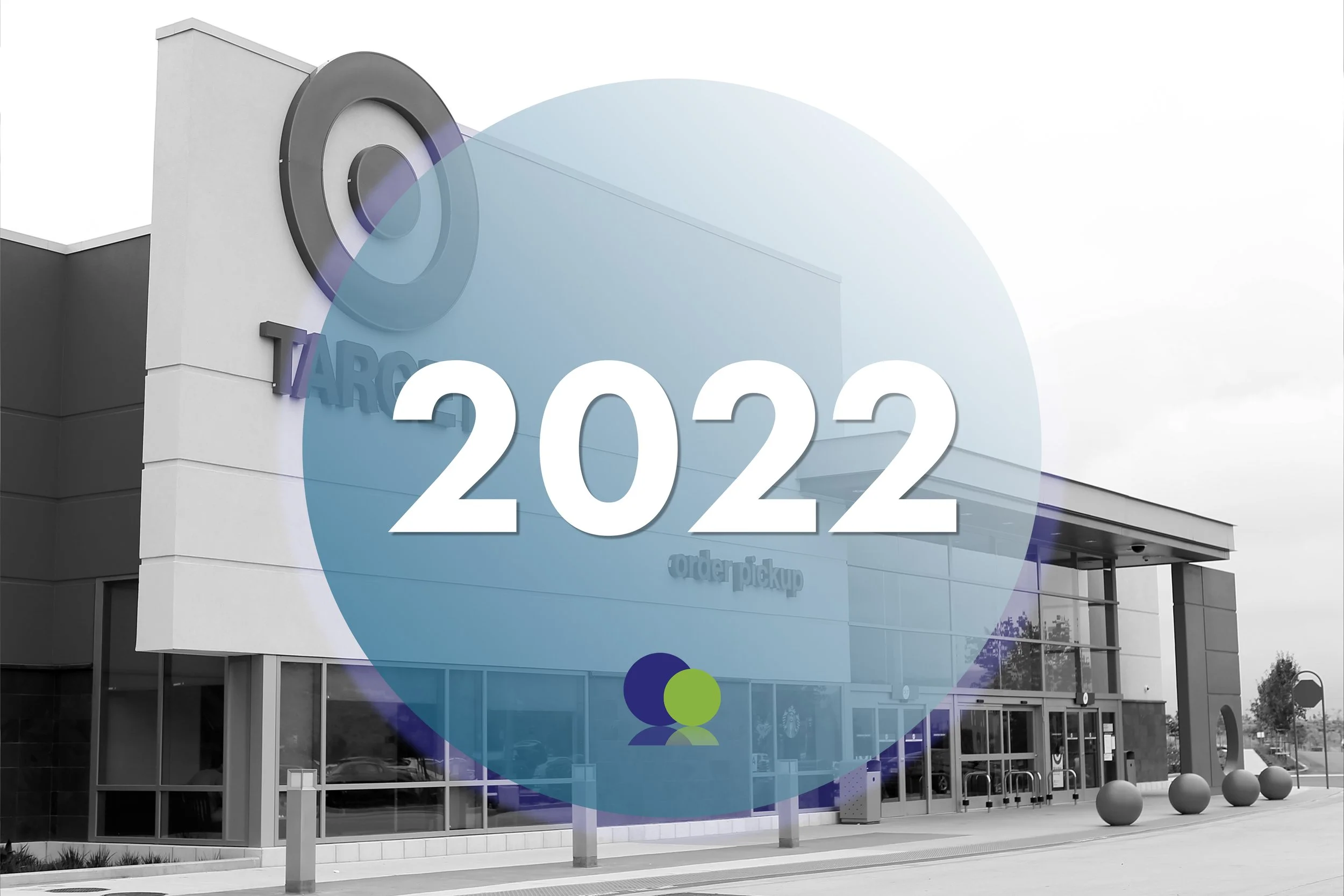 Vue extérieure d'un magasin Target avec une grande enseigne et un panneau circulaire bleu avec "2022" écrit en blanc, devant un centre commercial.