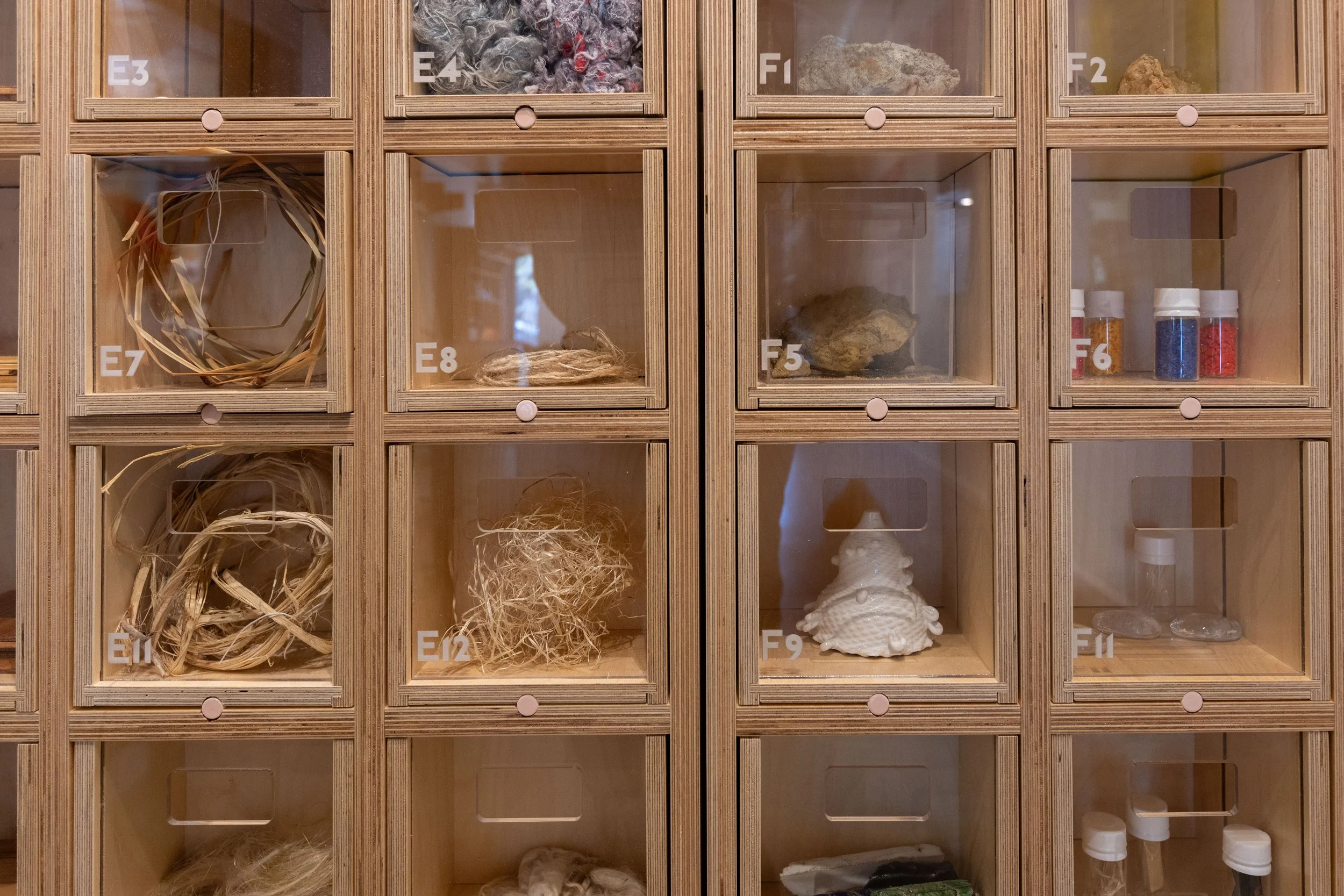 Detail of labeled material sample drawers in the Materials Collection  at Center for Craft, showing raw fiber, stone, ceramic, and pigment  samples