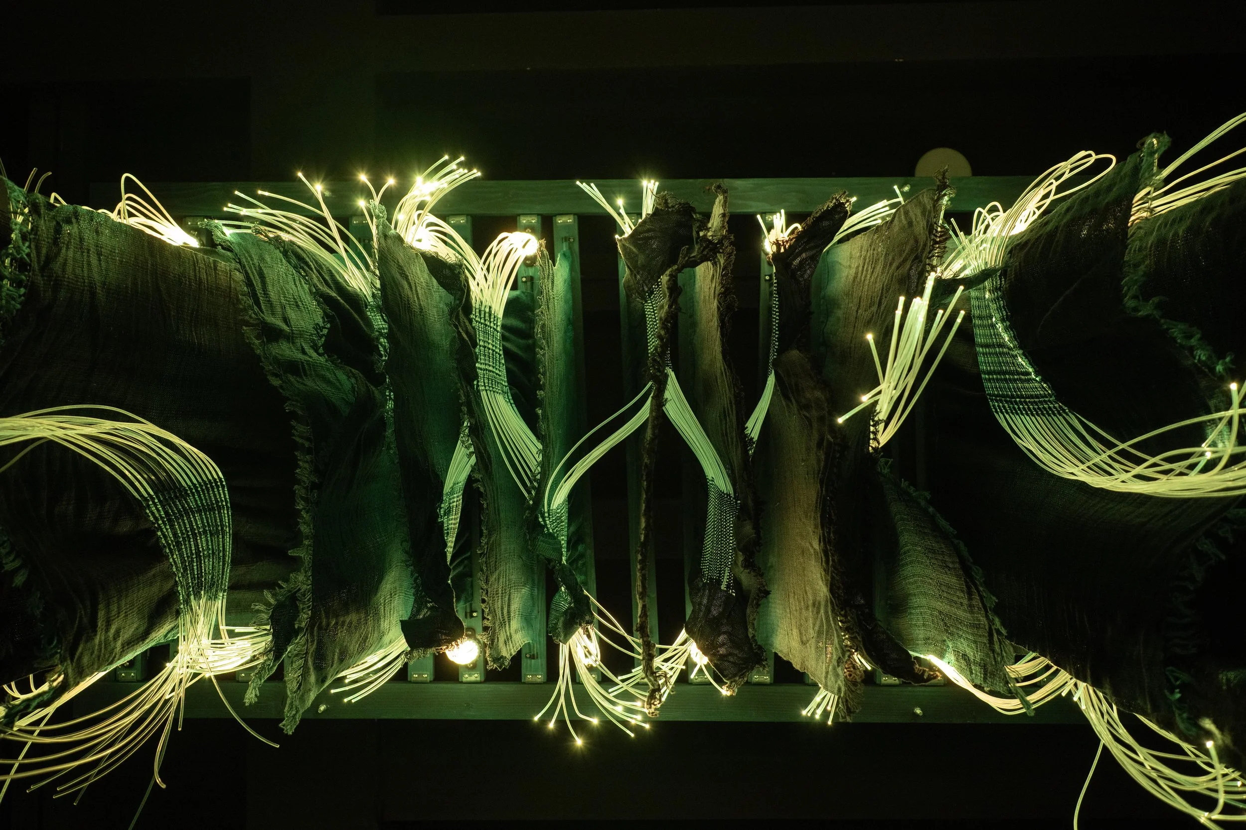 Close-up of Ancient Futures fiber optic weaving showing sentiment-based color patterns