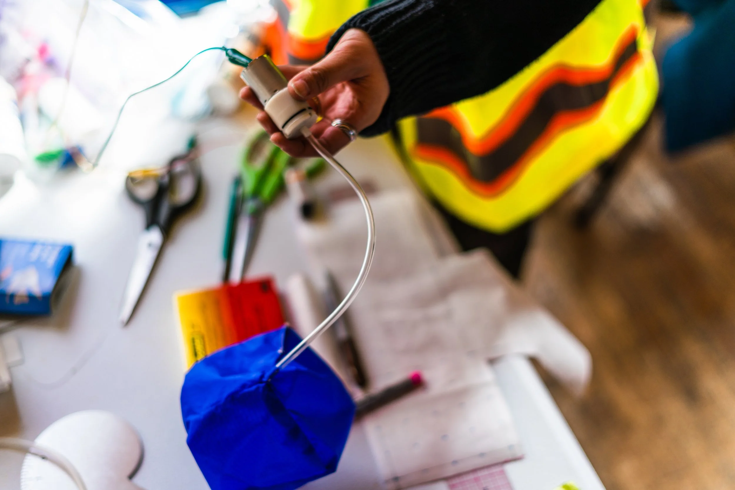 Close-up of hands assembling colorful electronic textile components and conductive materials during Electronic Textile Camp (ETC) co-organized by Craftwork