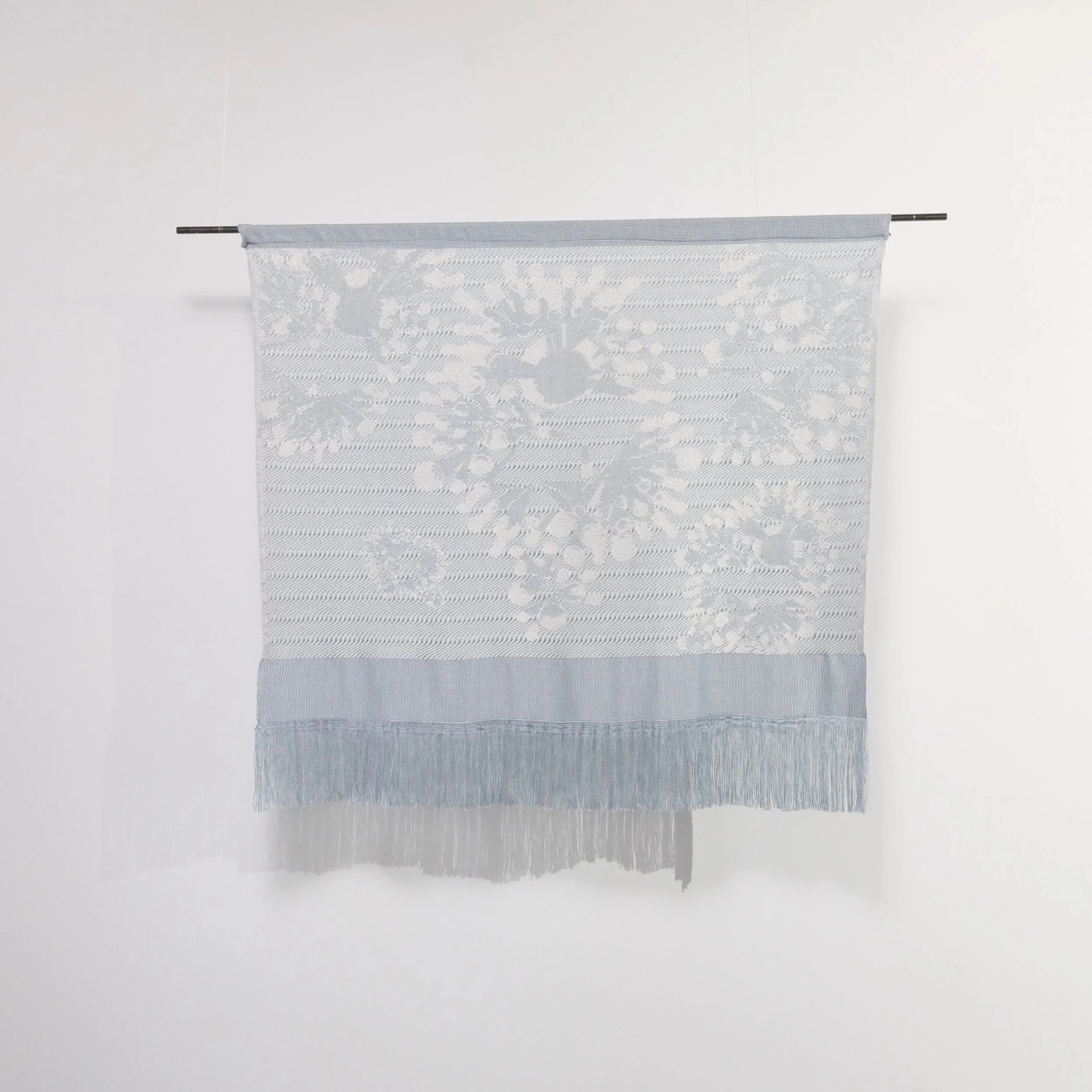 Slow Medium woven wall hanging in pale blue and white with fringe,  showing lichen-inspired weave pattern, by Craftwork