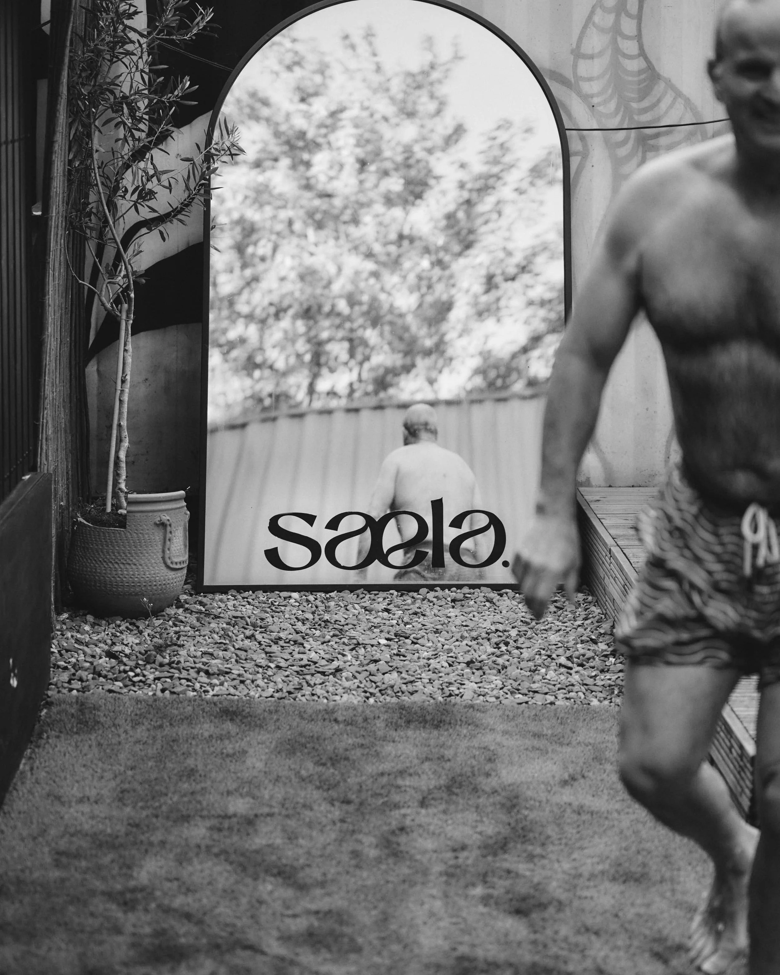 Reflection image of exterior mirror for Saela Sauna with a male customer recently exiting the cold plunge for Contrast Therapy. Commercial content social photography in Newcastle upon Tyne UK 